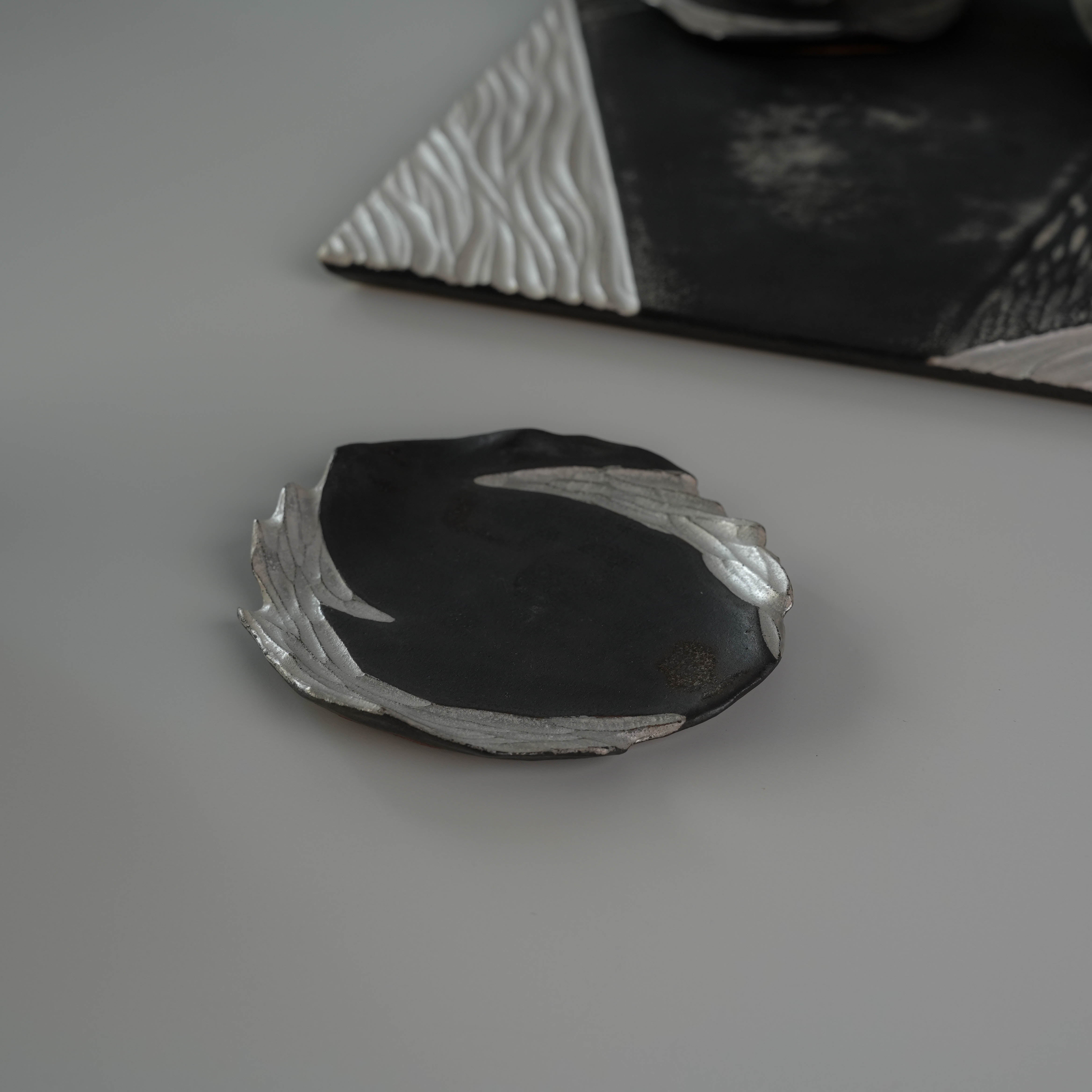 Single saucer from the Lonesome Studio Gushan Tea Set with silver and black handmade detailing, part of the elegant tea set collection.
