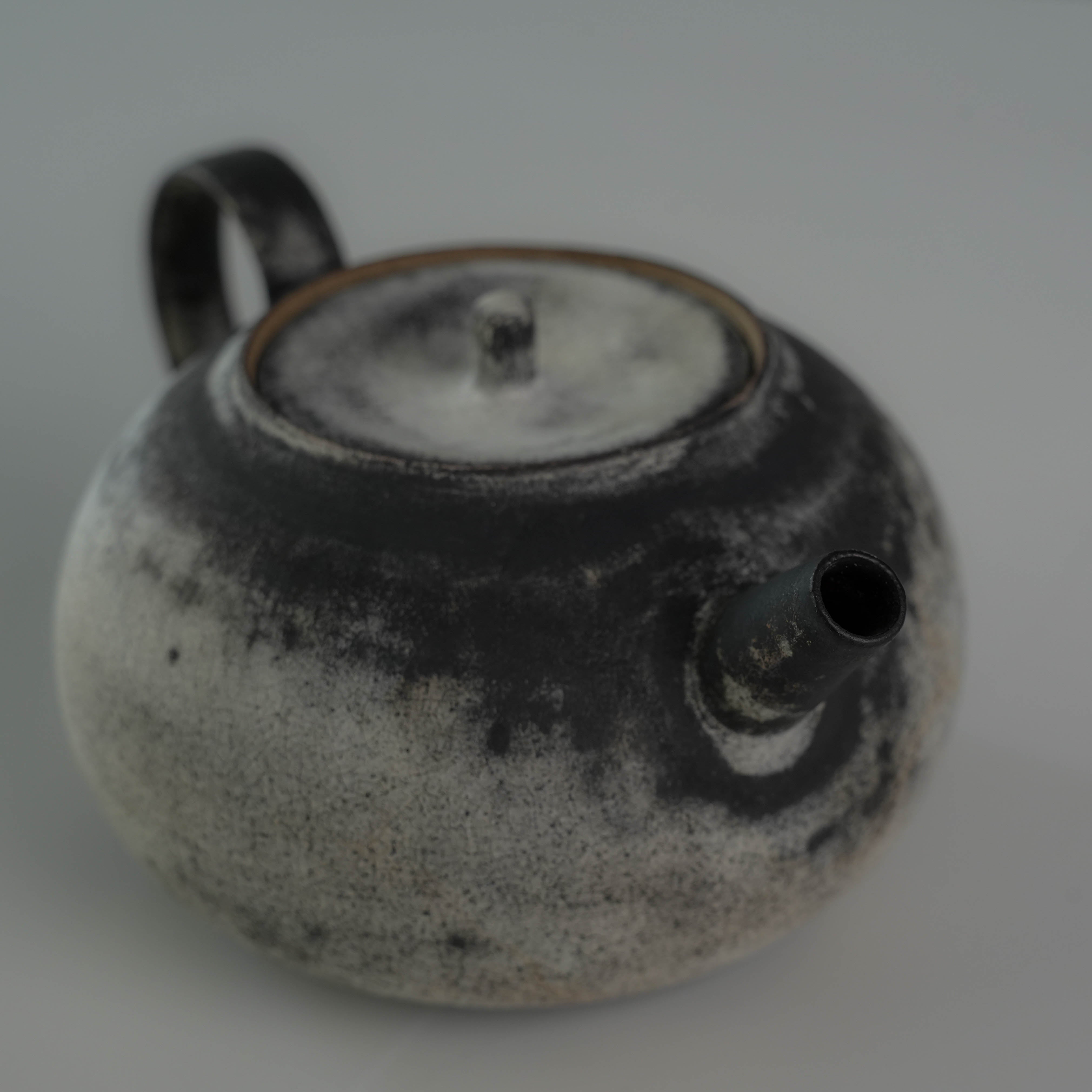 Front view of Lonesome Studio Gushan Tea Set teapot spout and lid, highlighting the rustic handmade glaze and elegant form.