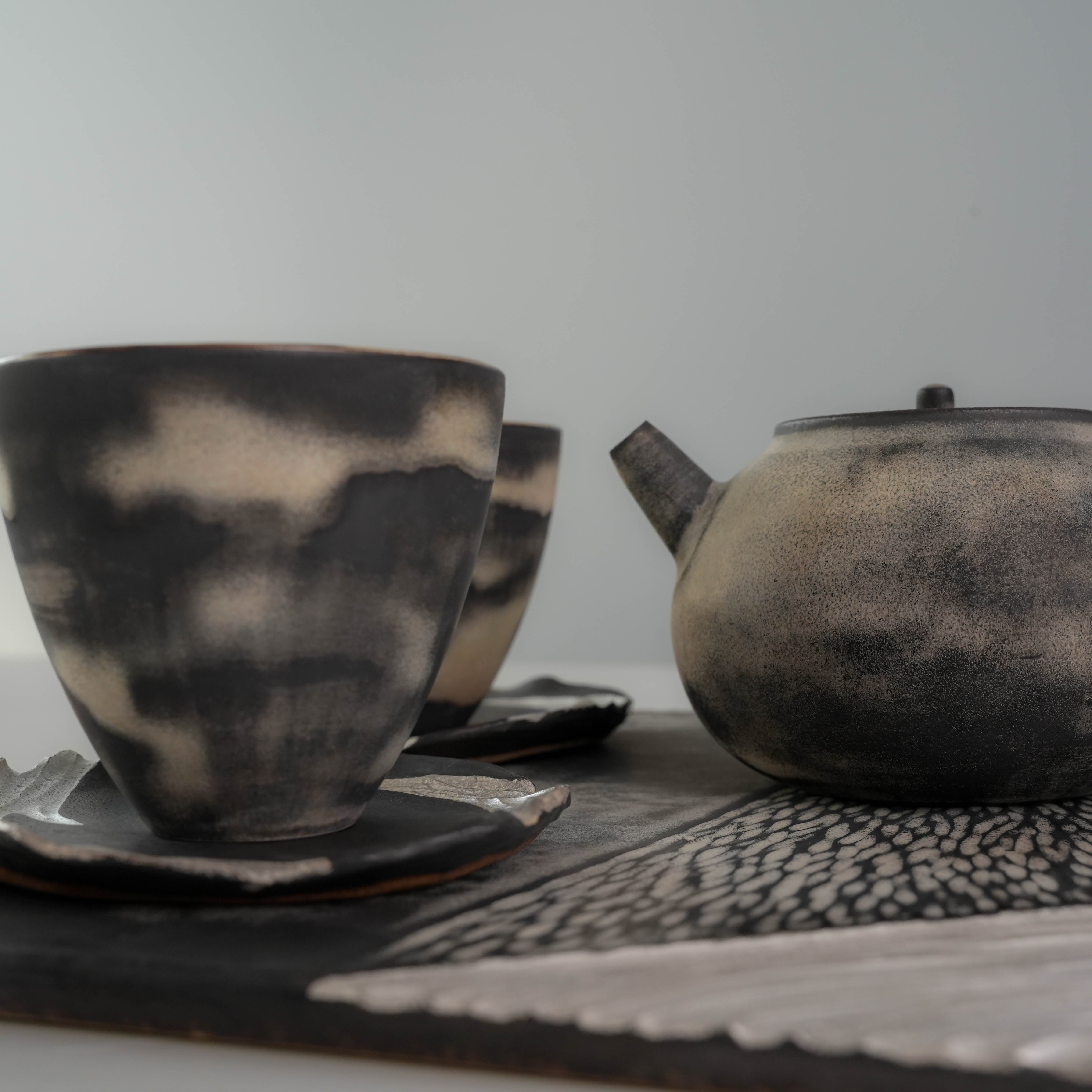 Close-up of Lonesome Studio Gushan Tea Set teapot and cups, emphasizing the handmade glaze and elegant design.