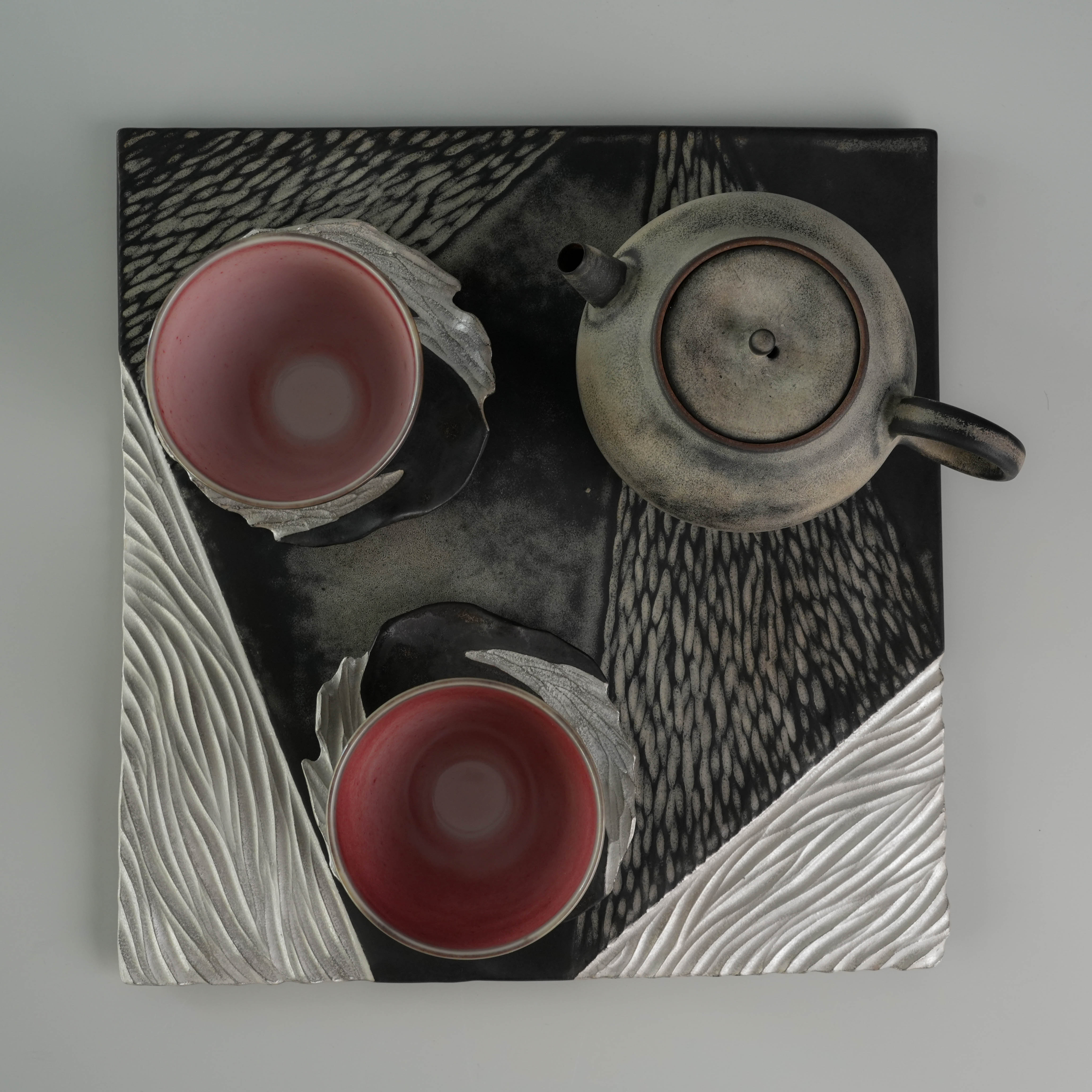 Top-down view of Lonesome Studio Gushan Tea Set with two cups and teapot on a silver-glazed geometric tray.