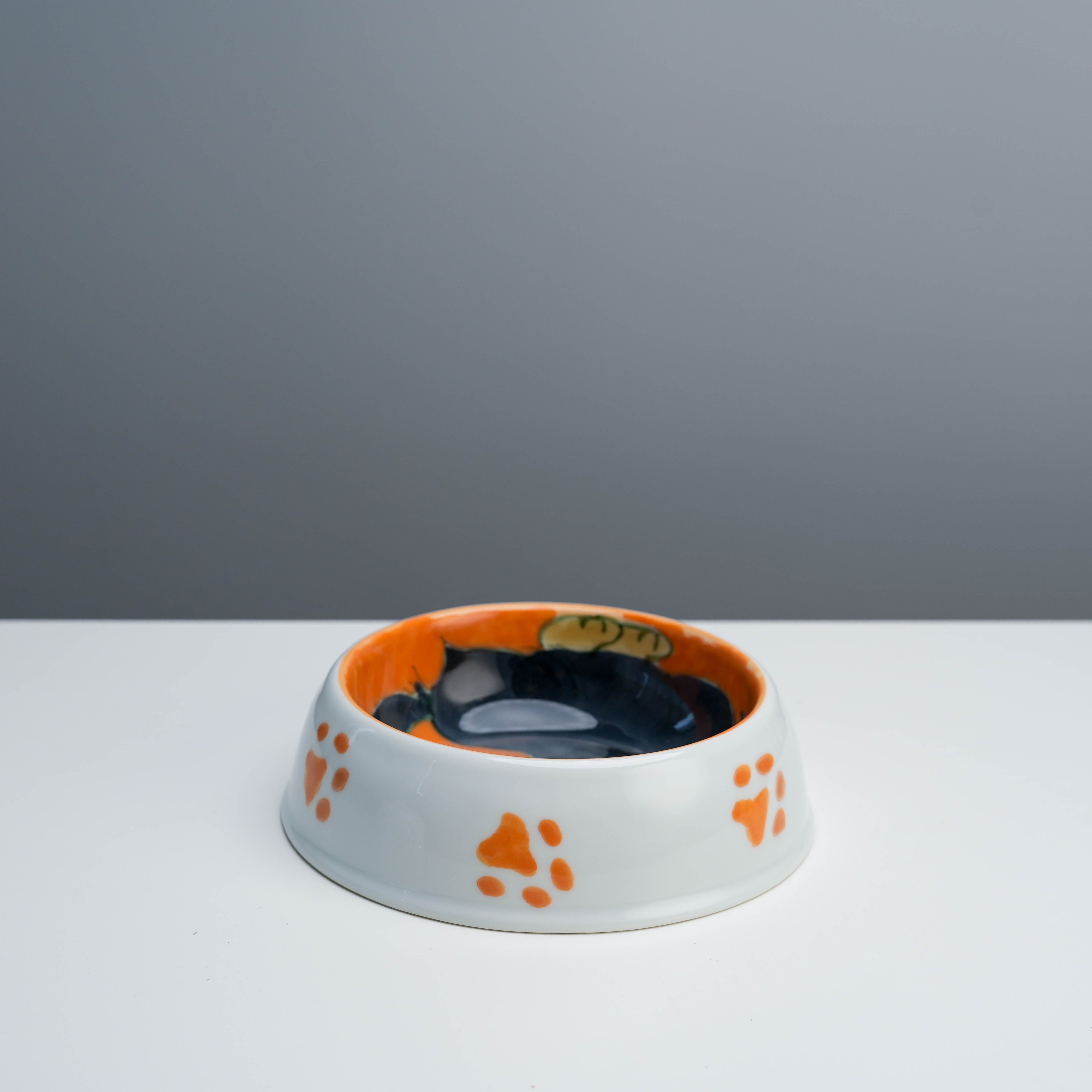Durable ceramic Arita Ware Dog Bowl with orange paw prints and hand painted dachshund, perfect for stylish pet feeding.