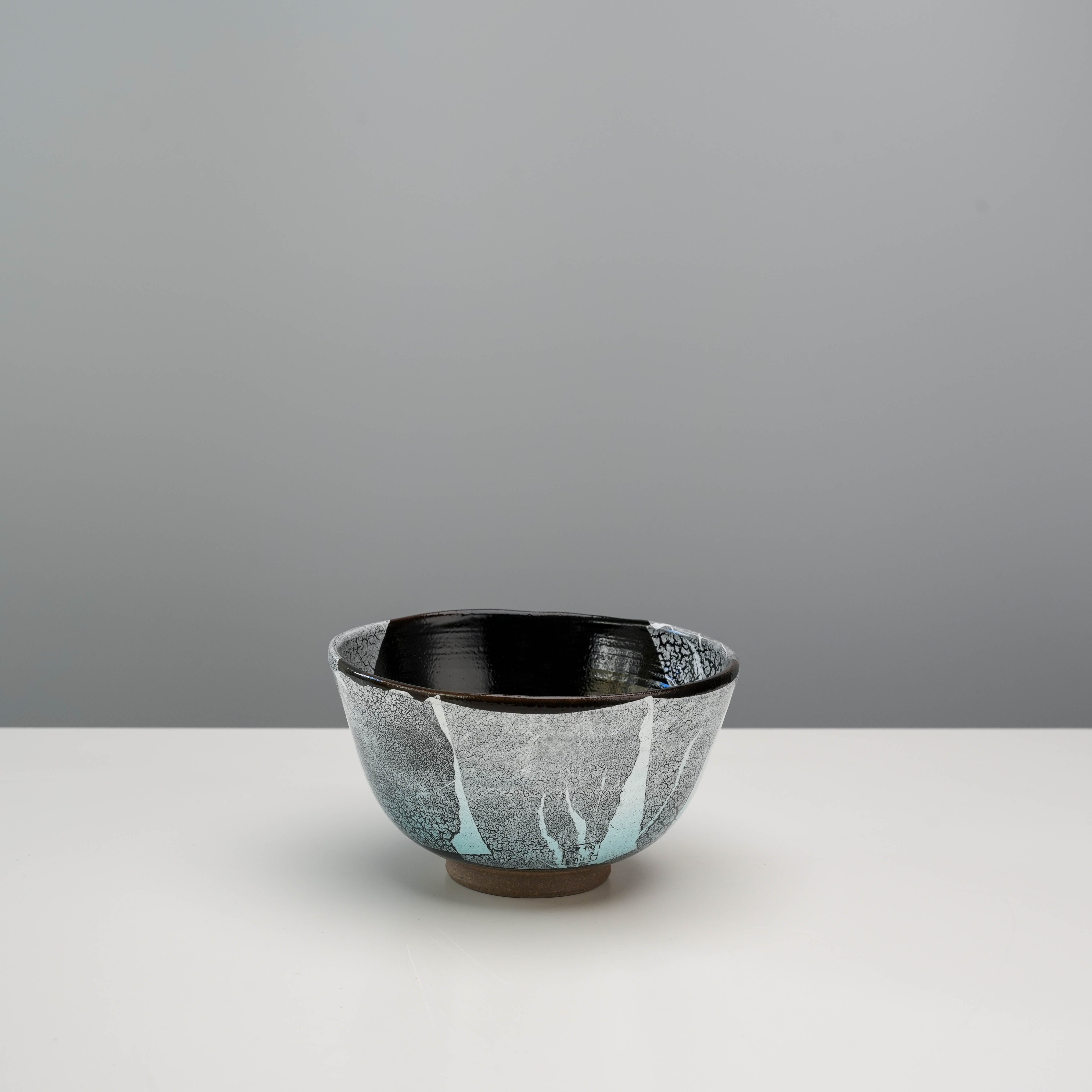 Elegant Kutani Ware Silver Leaf Matcha Bowl featuring a deep black glaze and silver foil textures, suitable for tea or display.