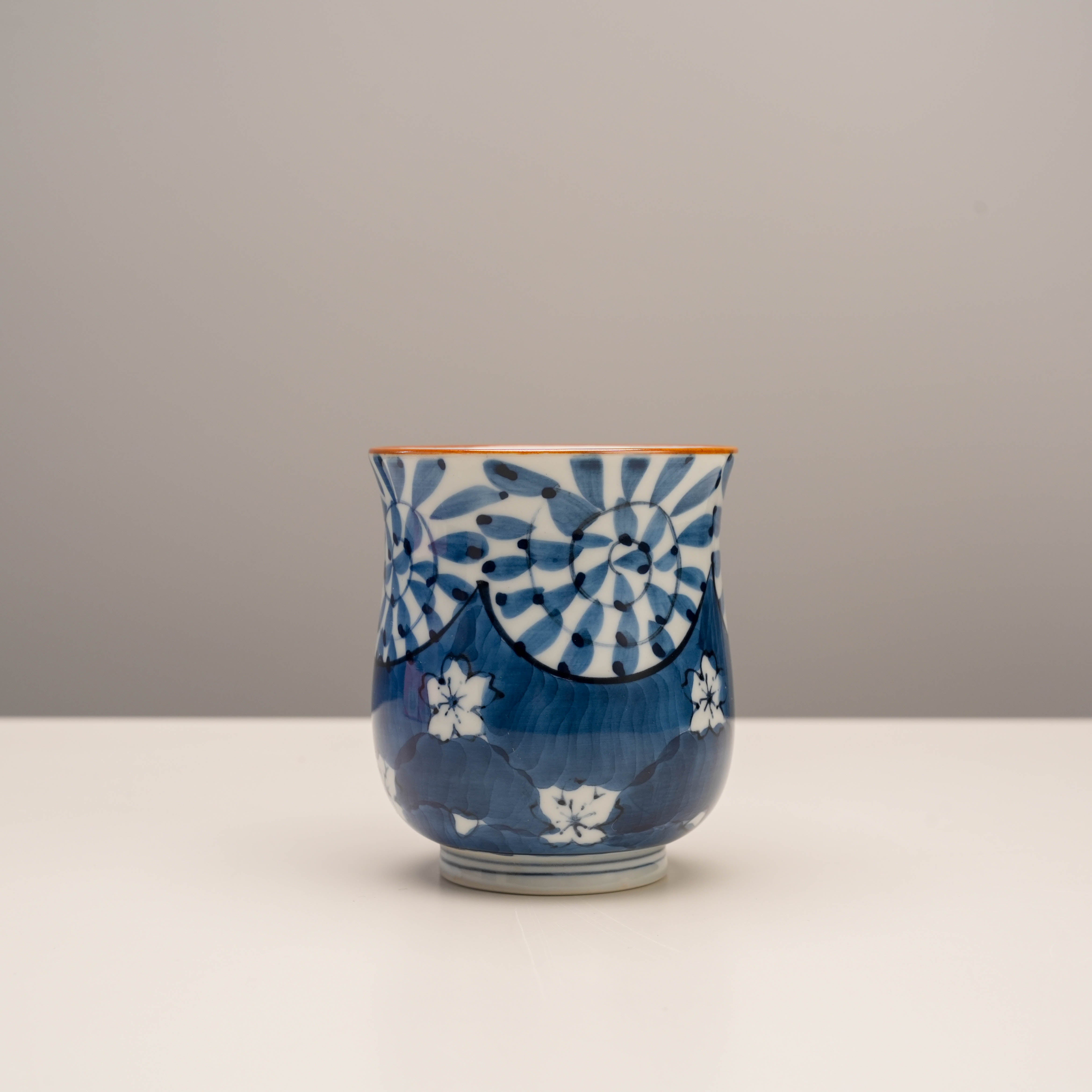 Blue Arita Ware Yunomi tea cup with intricate arabesque and cherry blossom design. Hand-painted Japanese porcelain for elegant tea service.