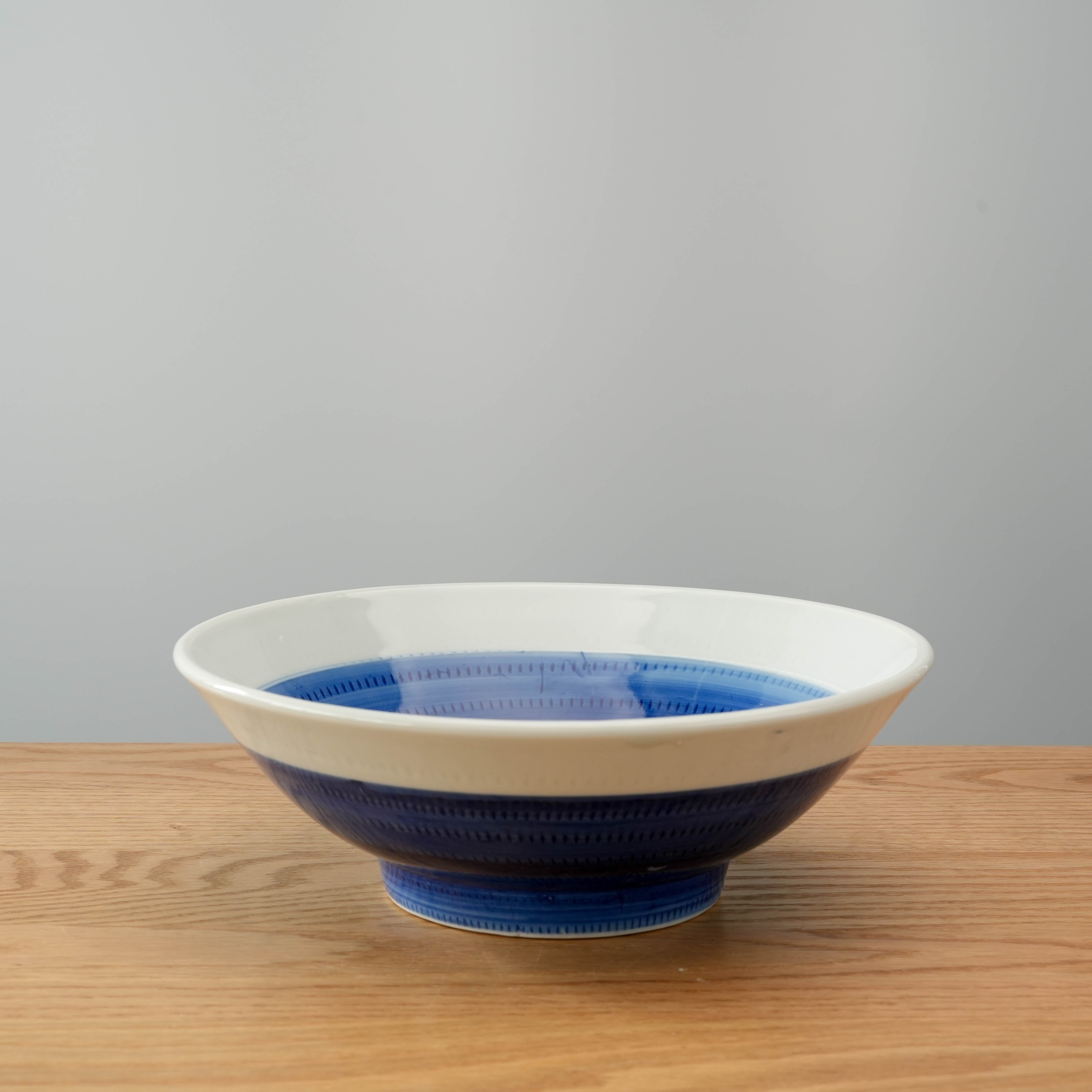 Angled view of Mino Ware Tochiri Bowl - Donburi, featuring a wide opening and traditional Japanese brush pattern design in blue tones.