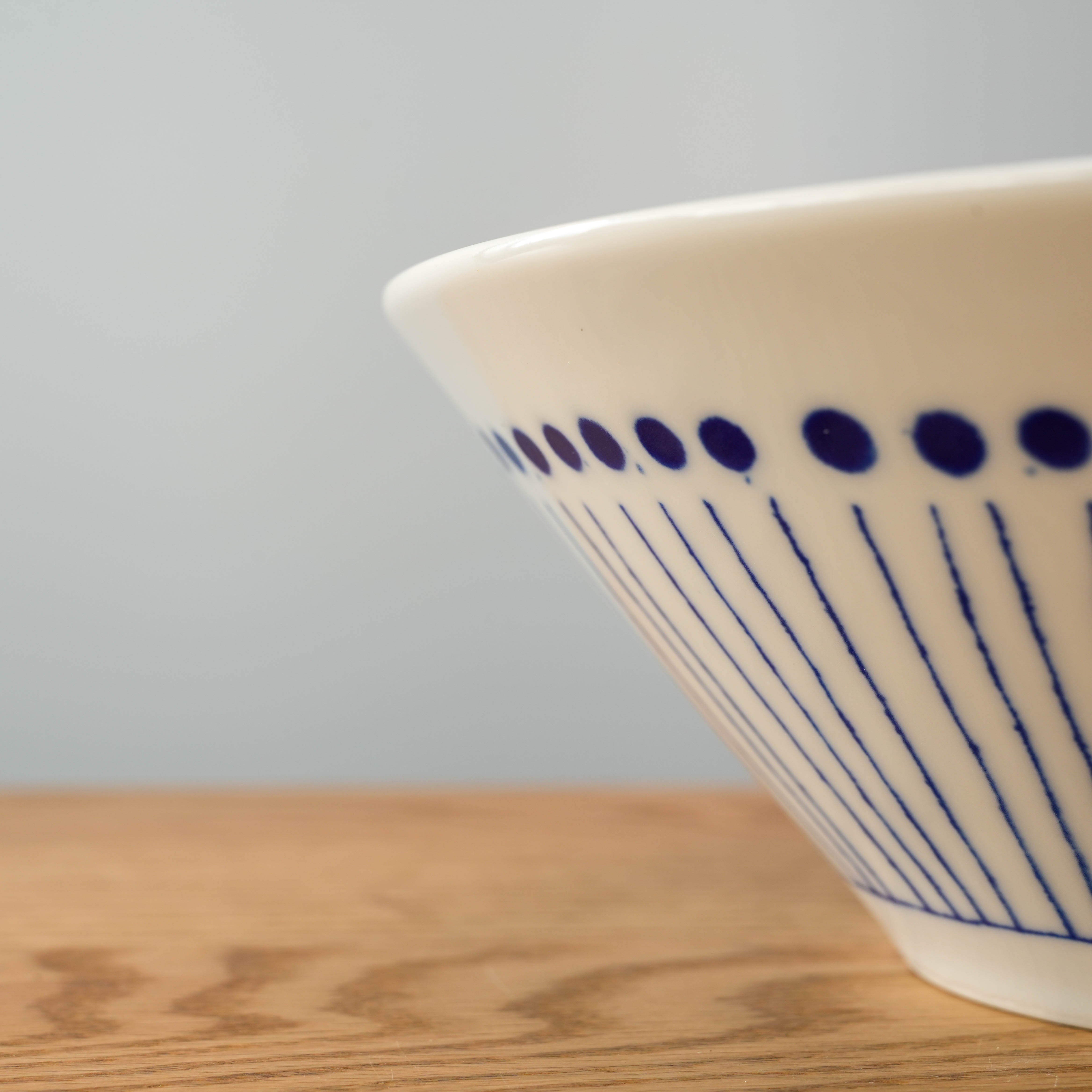 Close-up of Blue Tokusa Dot Bowl's exterior pattern with indigo dots and vertical lines, showcasing Mino Ware craftsmanship.