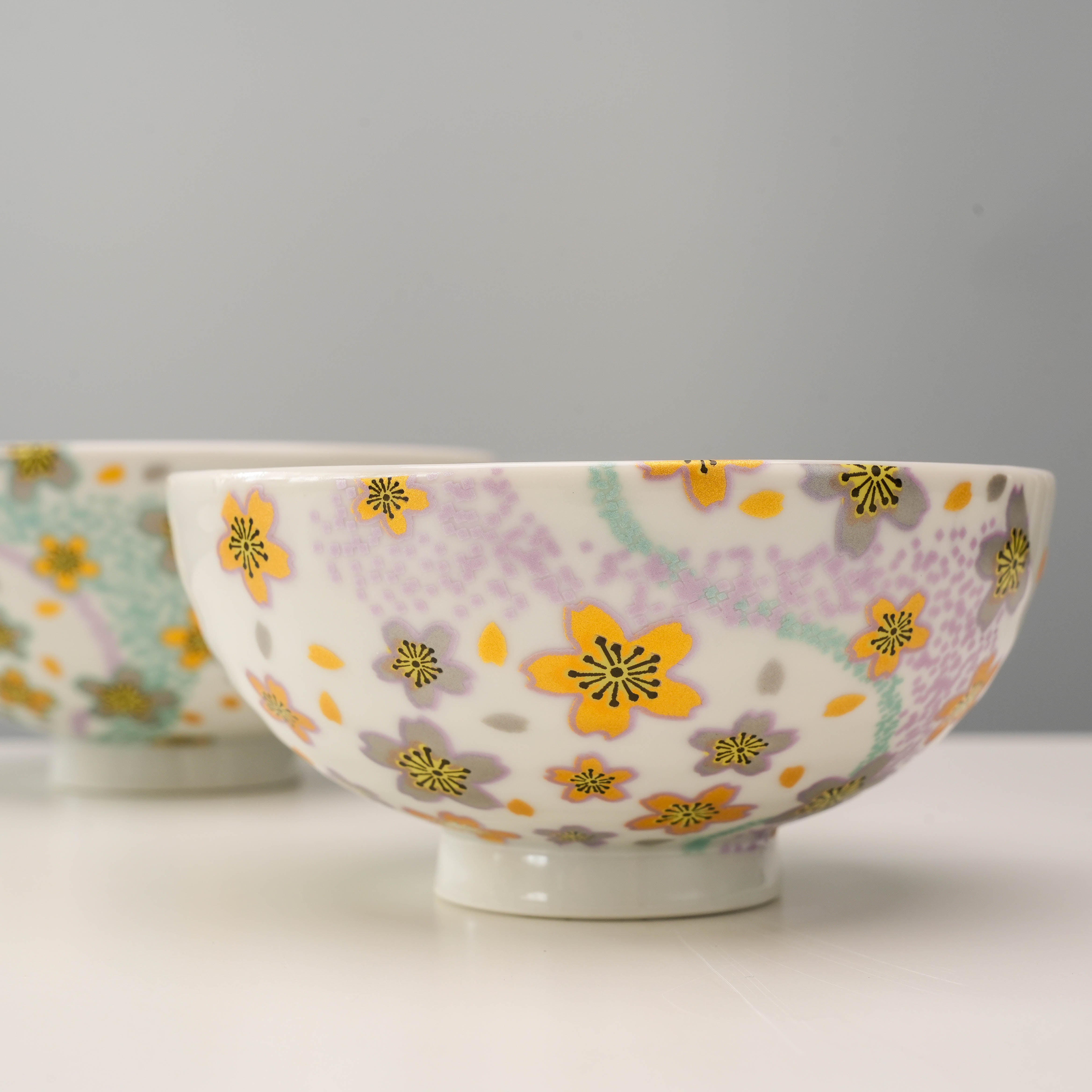 Detail of pastel purple and yellow floral design on Kutani Ware Kyokusui Flower Rice Bowl, a charming gift for home and garden lovers.