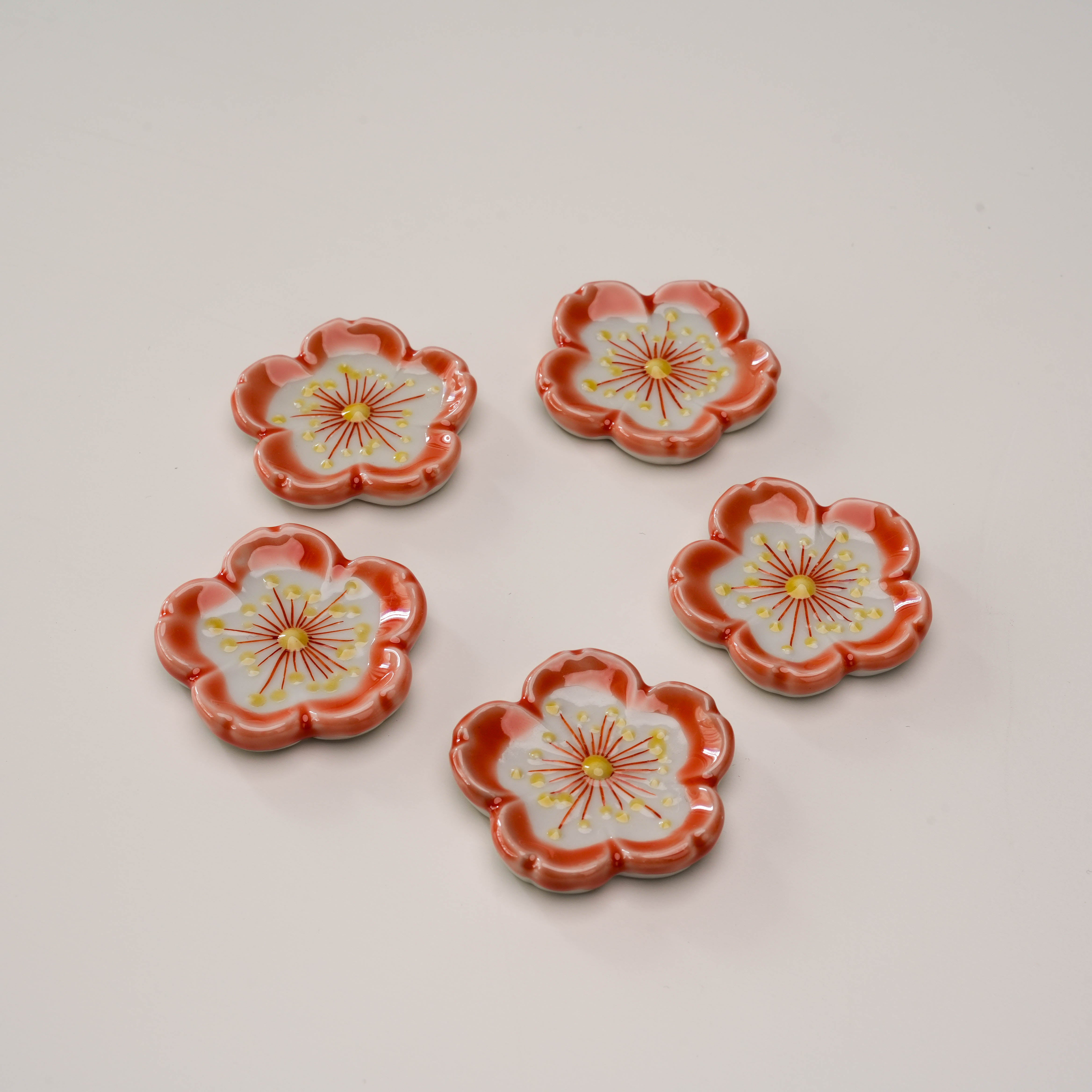 Set of 5 Kutani Ware Sakura chopstick rests arranged in a circle, highlighting intricate cherry blossom patterns for stylish table decor.