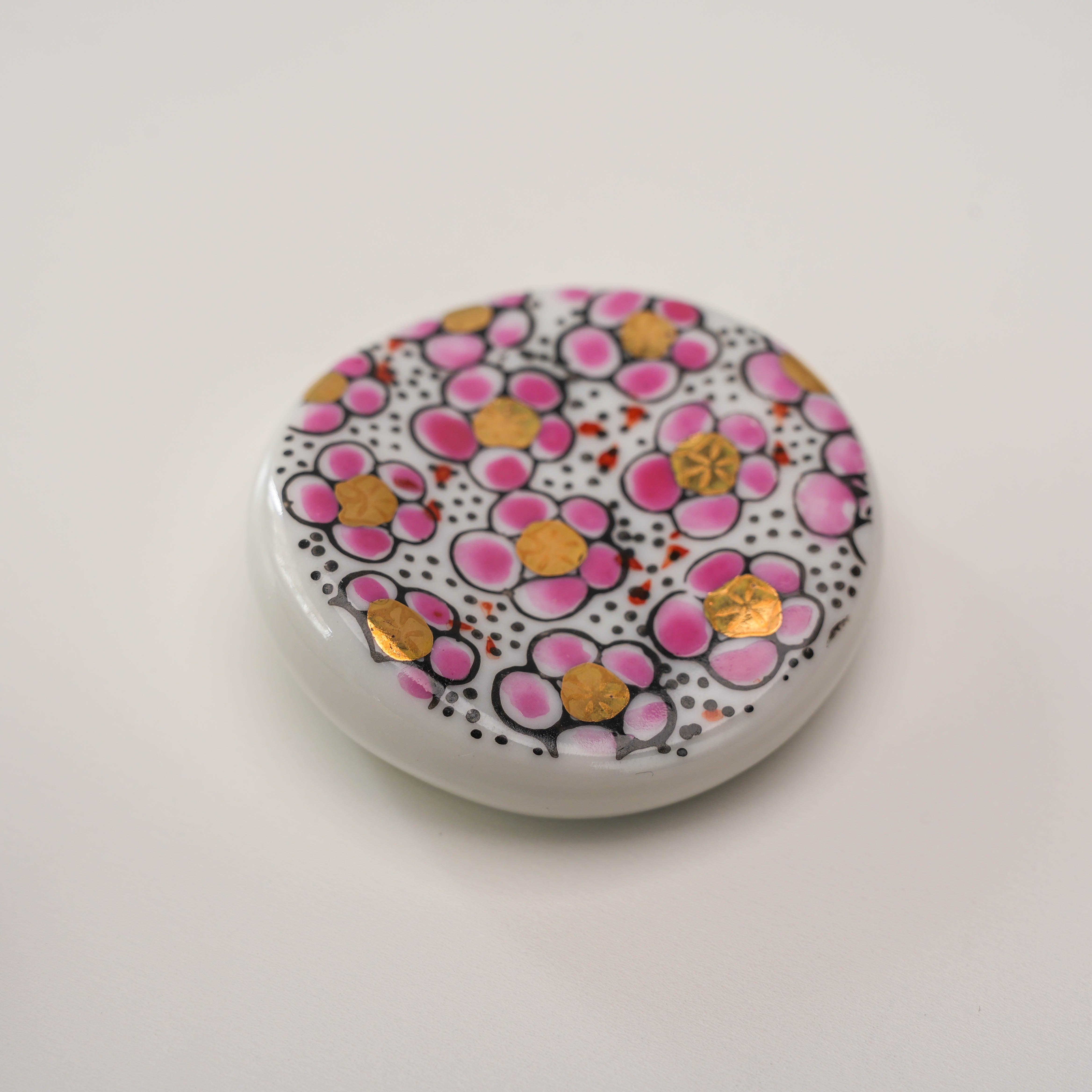 Detailed view of pink Kutani Ware Plum Blossom Chopstick Rest with gold highlights, perfect for enhancing dining aesthetics.