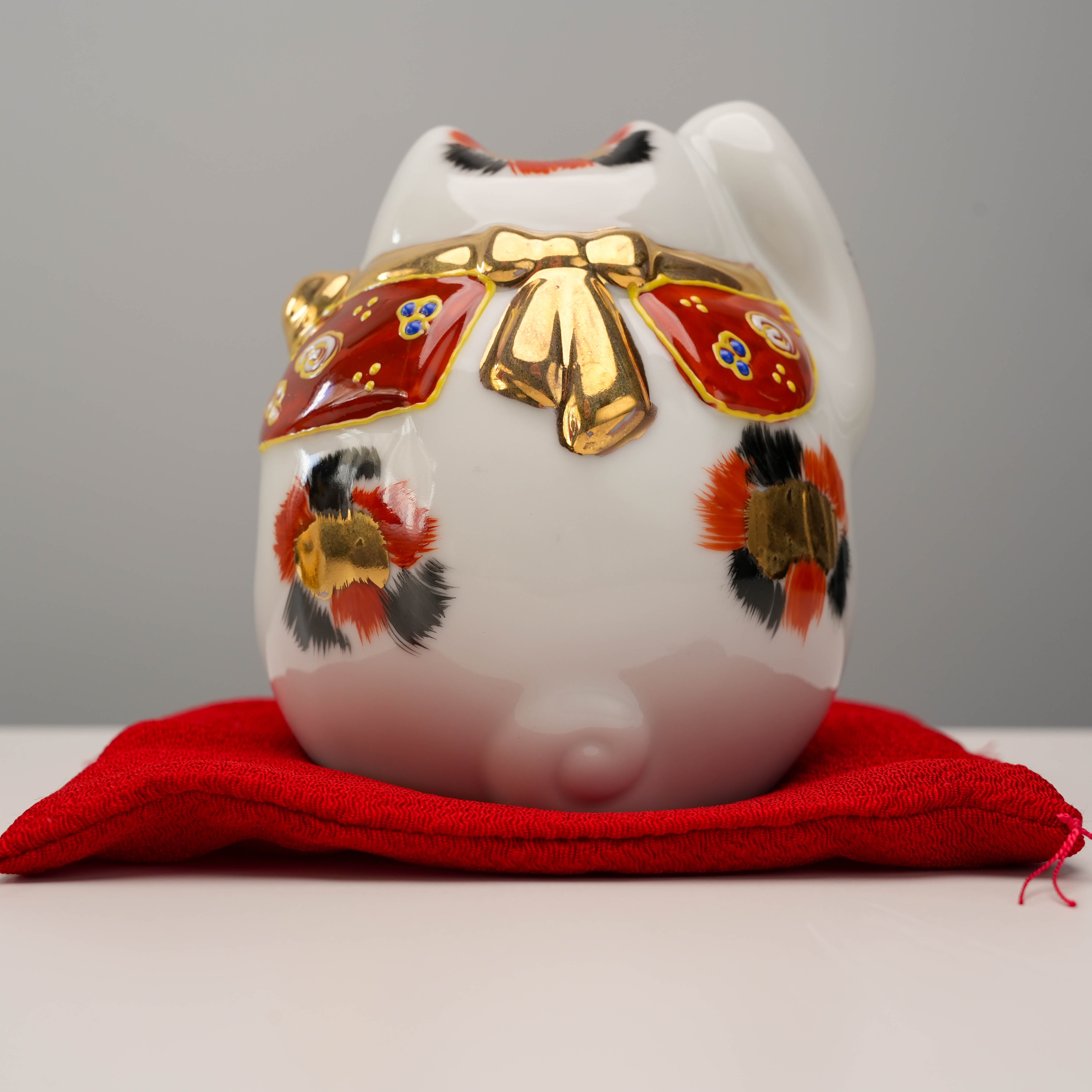 Rear view of Kutani Ware Cat – Lucky Calico highlighting golden bow and hand-painted calico spots, a joyful prosperity symbol.