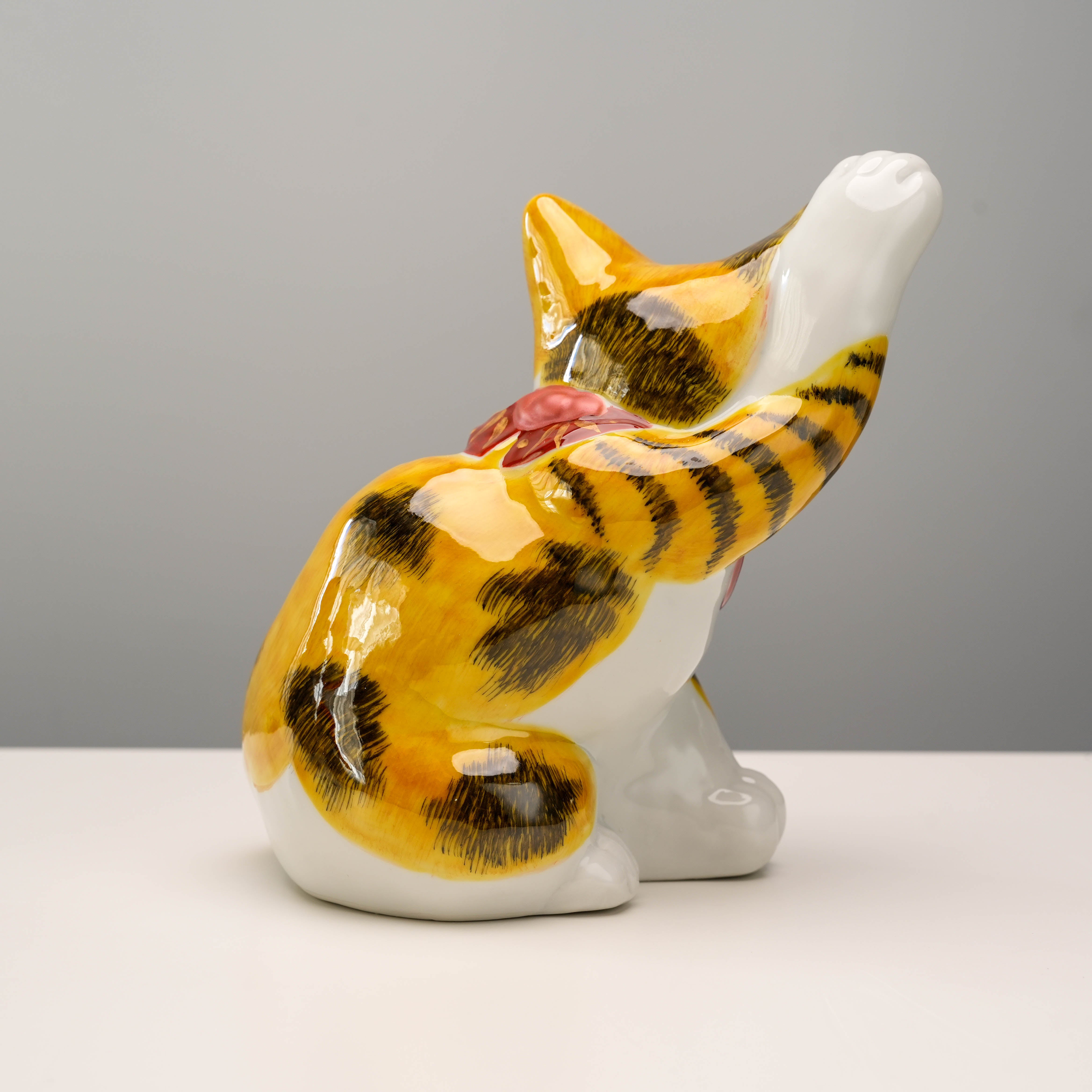 Side angle of Aokutani-style Kutani Ware Lucky Cat figurine with raised paw and vibrant calico glaze, perfect for decorative use.