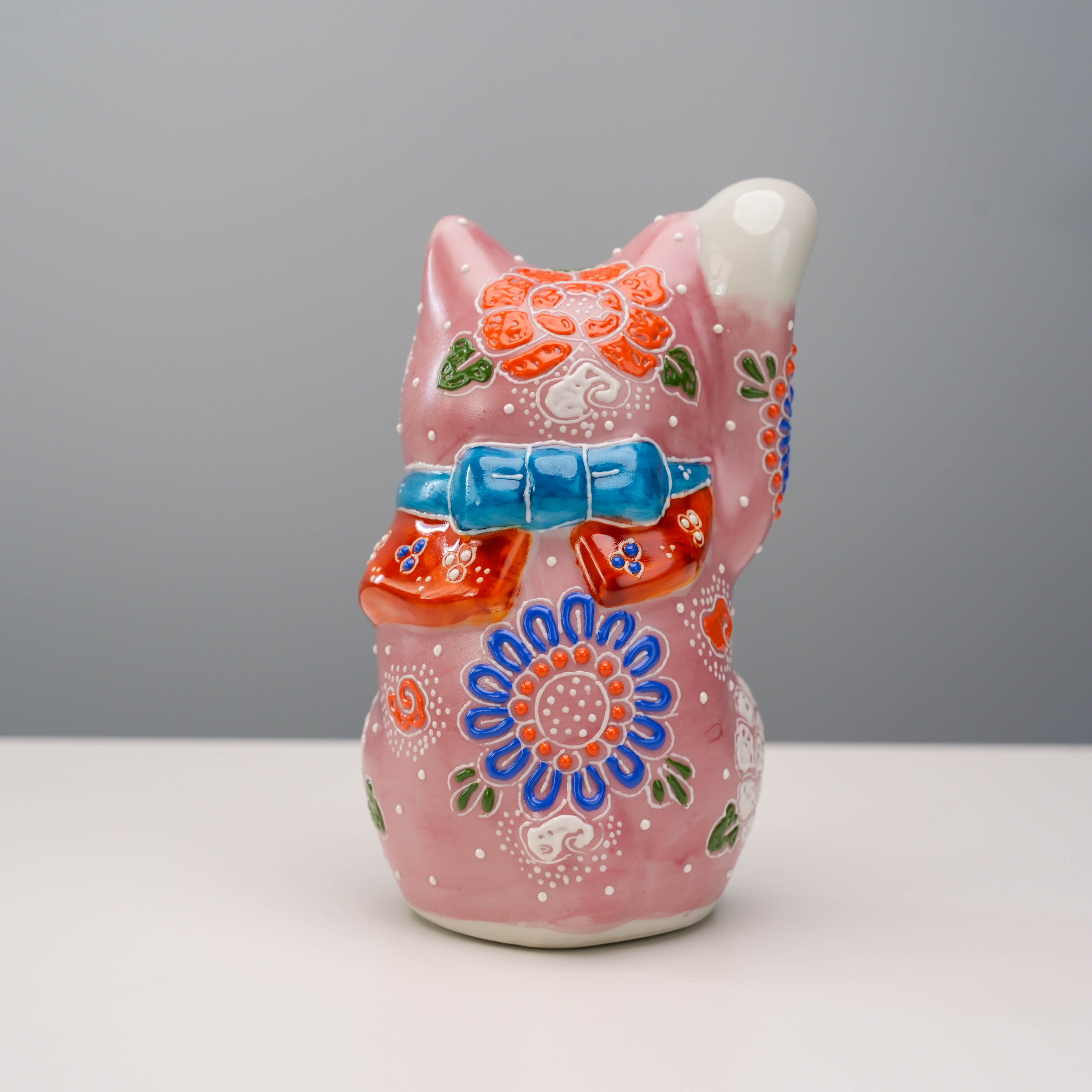 Back view of Kutani Ware Cat Ornament - Lucky Cat showing intricate hand-painted bow and floral motifs on glossy pink ceramic finish.