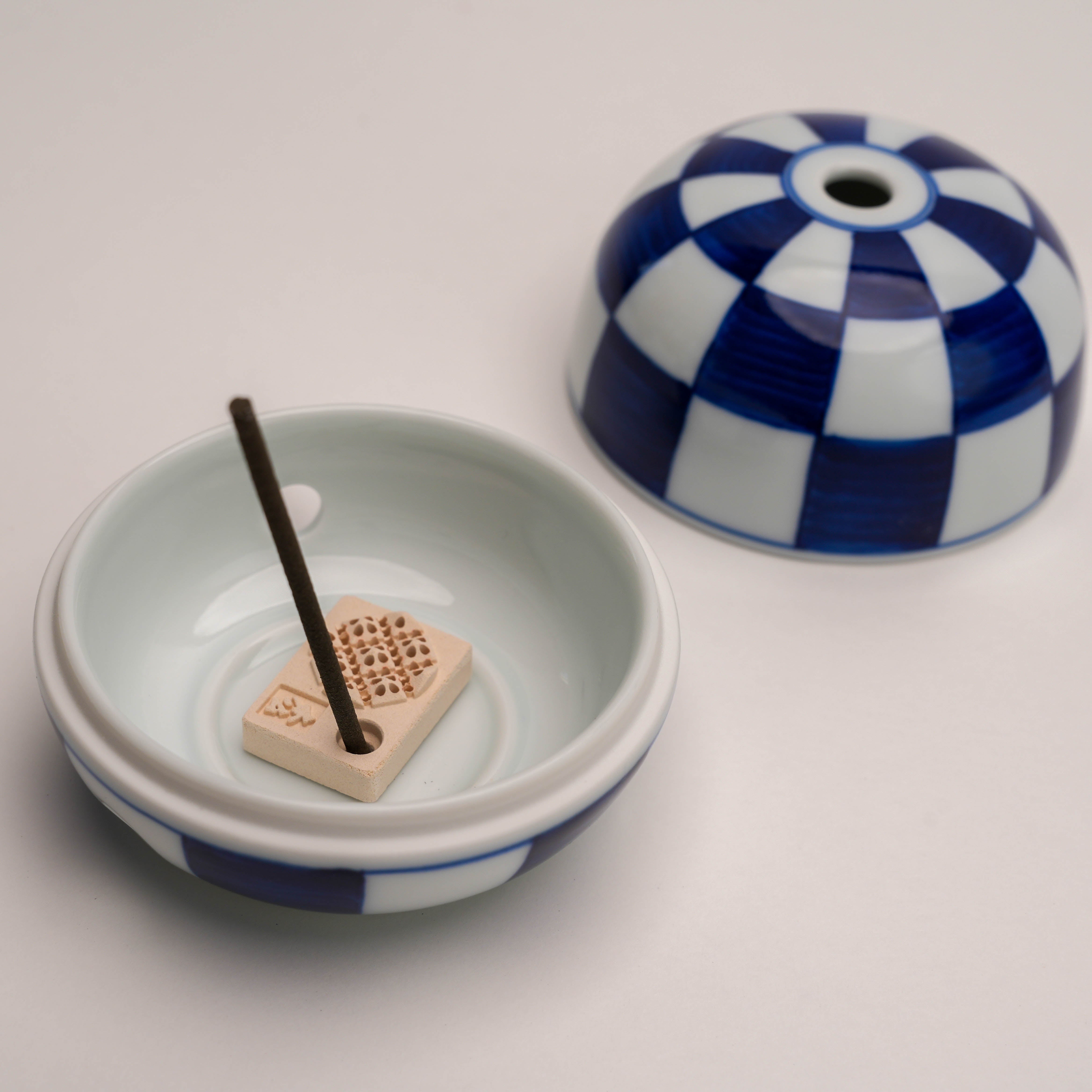 Shoyeido Miyuki Stone Incense Burner with incense stick placed inside, highlighting its multi-use design for serene home spaces.