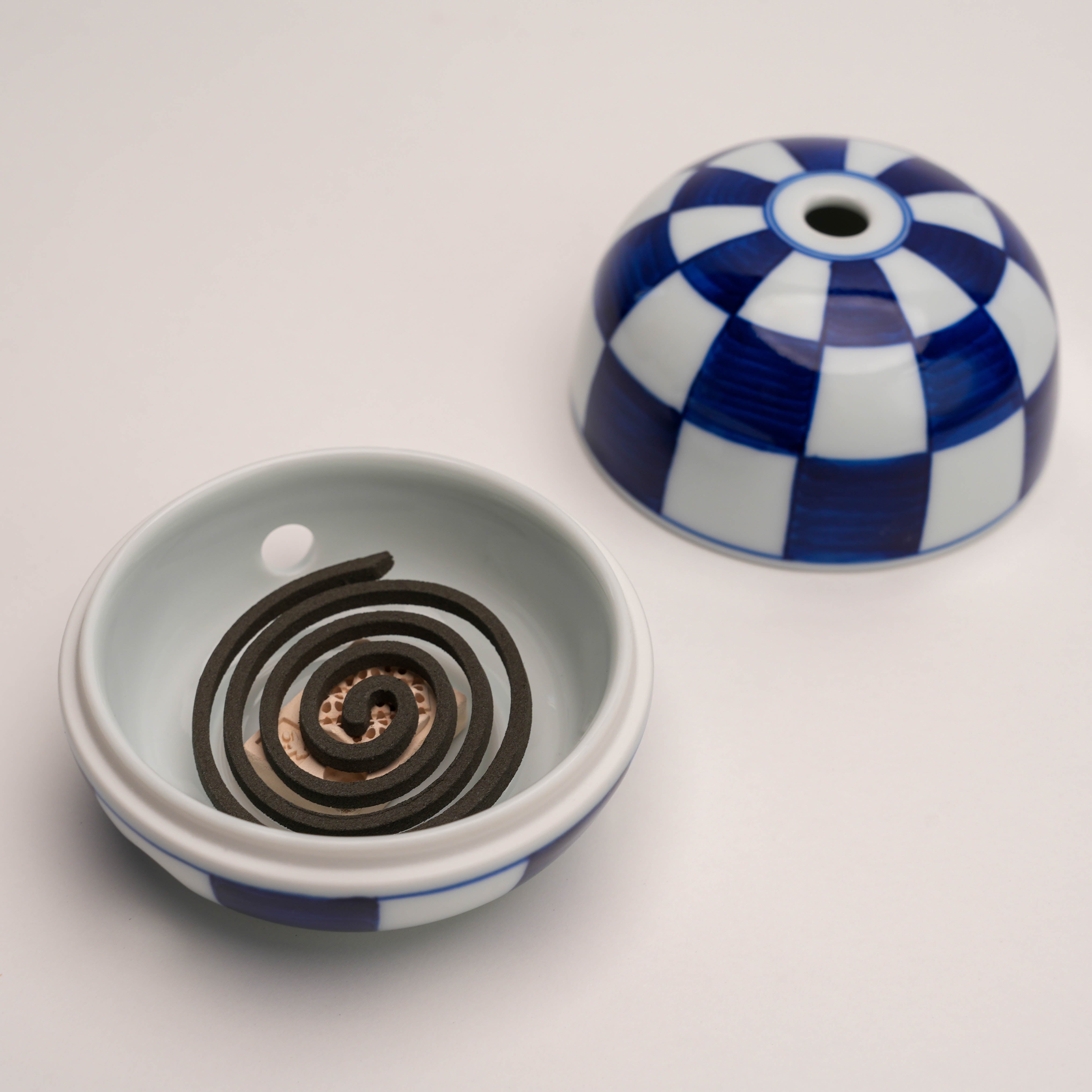Miyuki Stone Incense Burner by Shoyeido holding a spiral incense coil, demonstrating its functionality for various incense types.