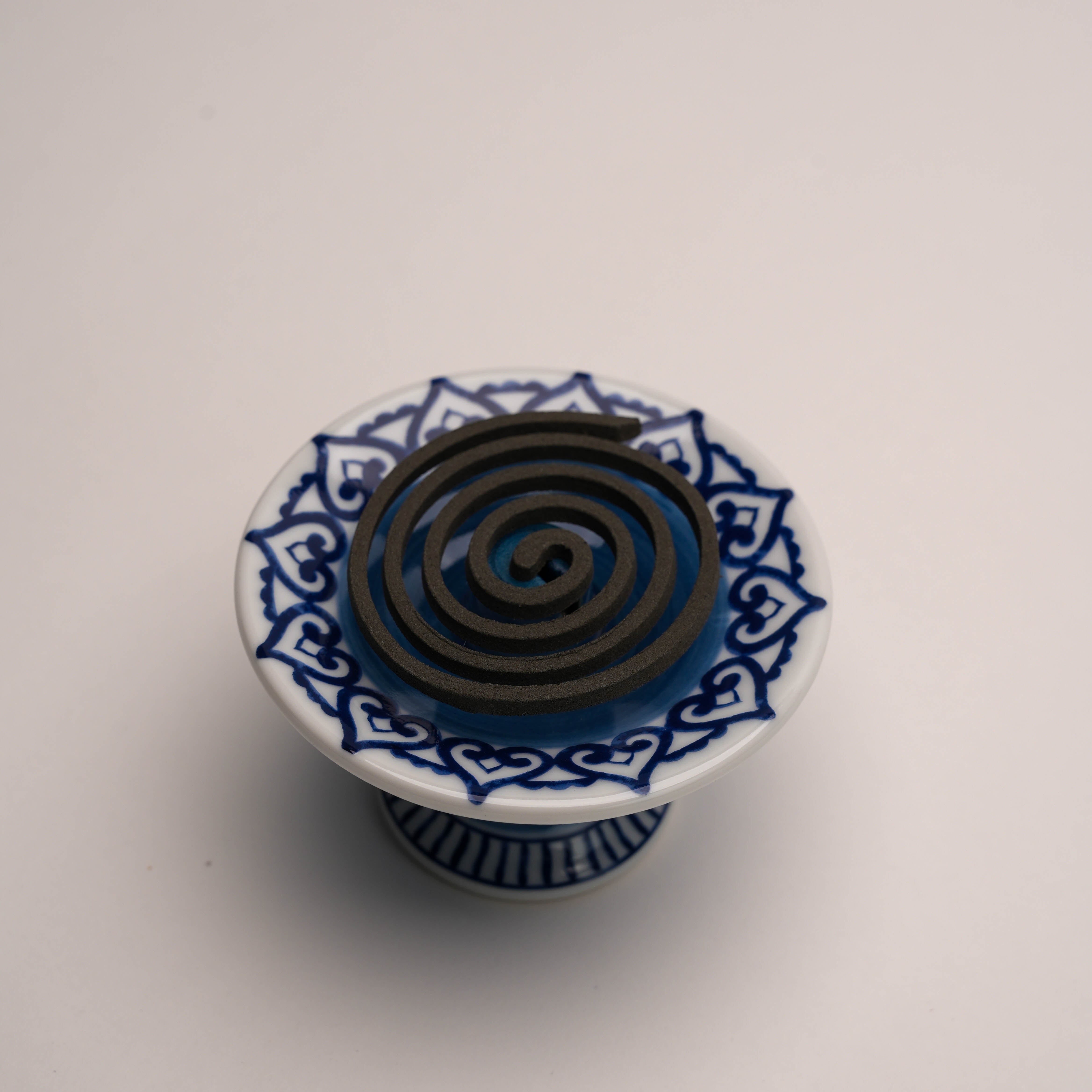 Close-up of Arabesque Incense Burner - Versatile Use | Blue Design with coil incense, emphasizing decorative ceramic surface and usability.