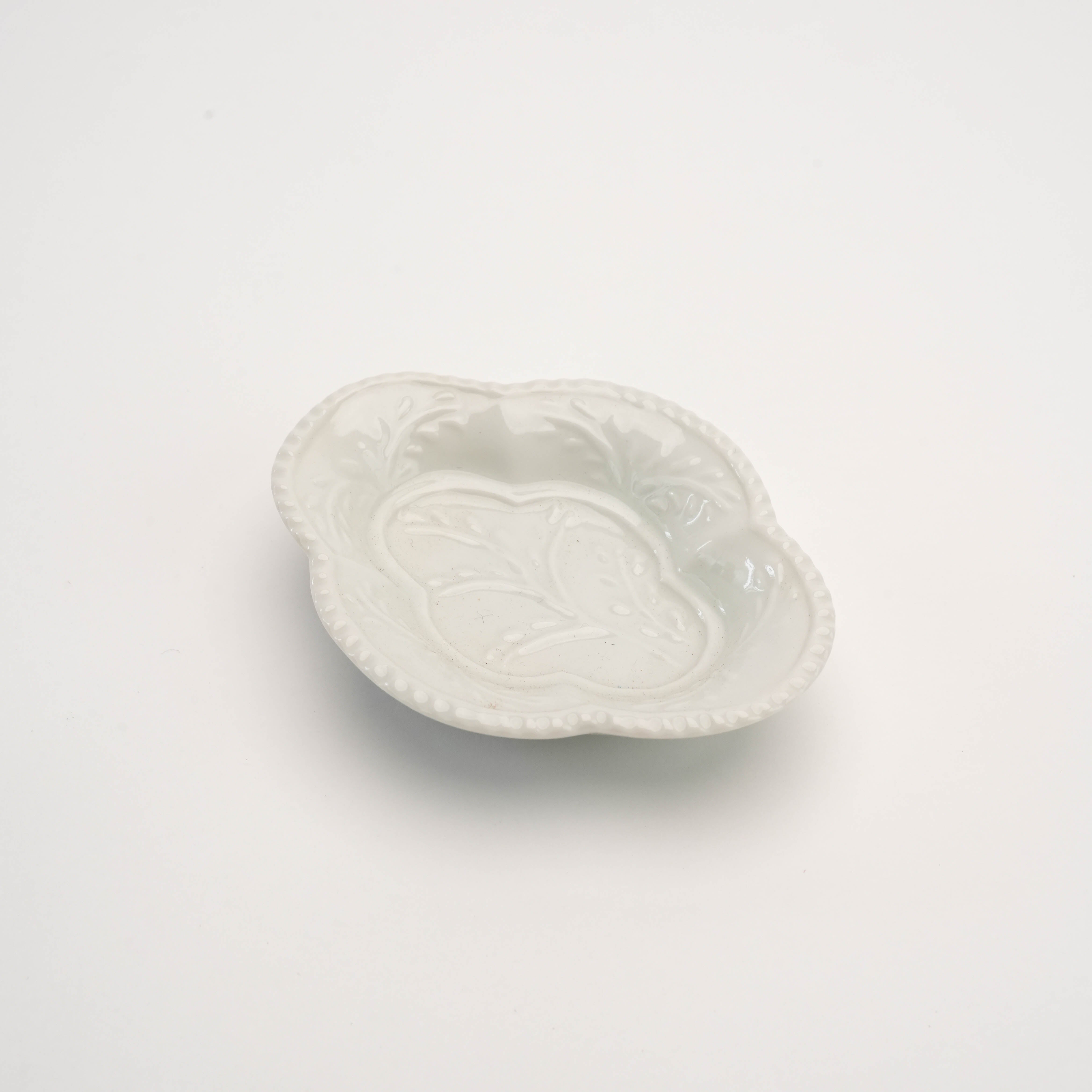 White Arita Ware Quince-shaped condiment dish with delicate leaf embossing and smooth glaze. A minimalist touch to elegant table settings.