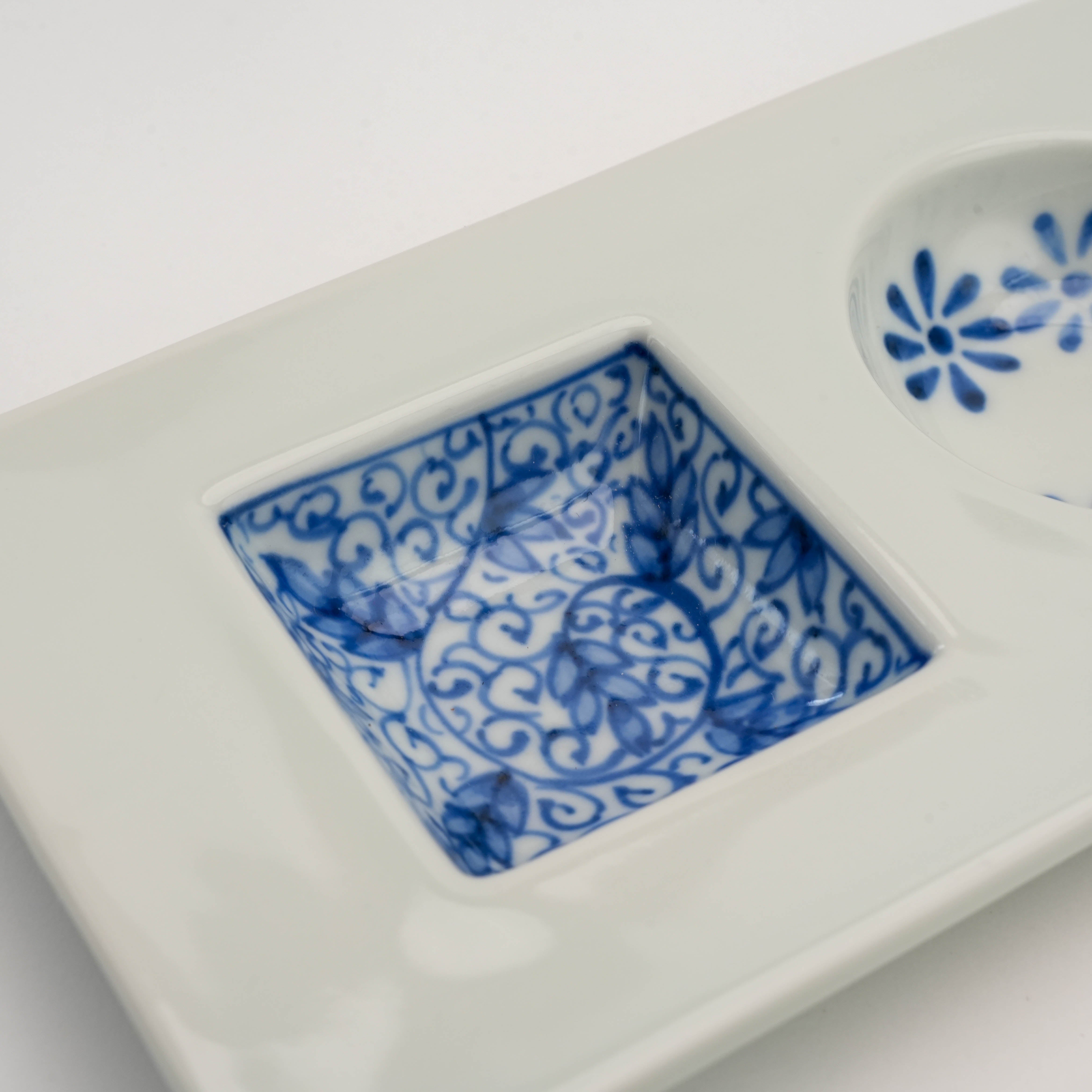 Close-up of scroll pattern in square compartment of Sometsuke Serving Dish, showcasing intricate blue detailing on white porcelain.