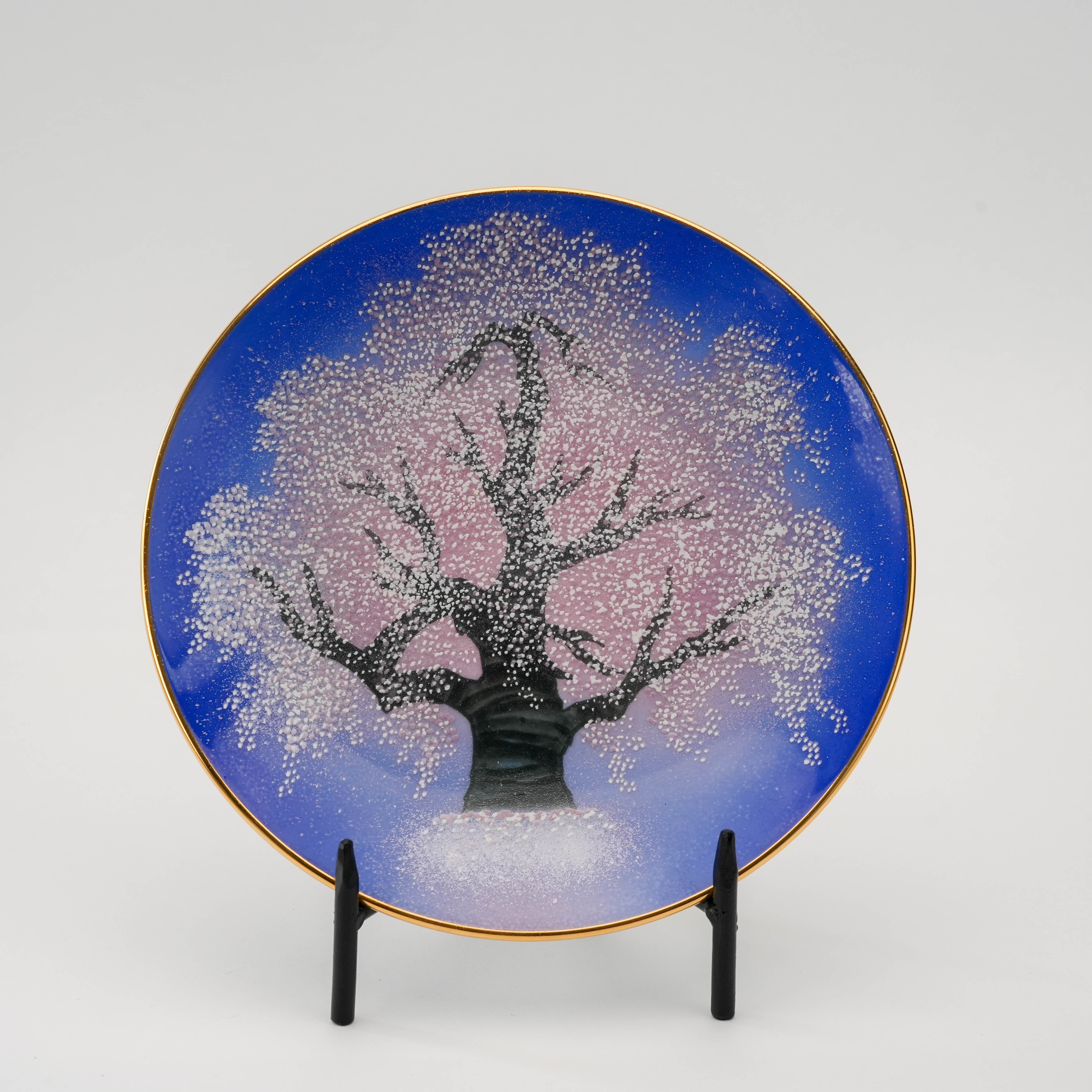 Close-up of the Arita Yozakura Cherry Blossom saucer with a hand-painted sakura tree in full bloom under a deep blue night sky.