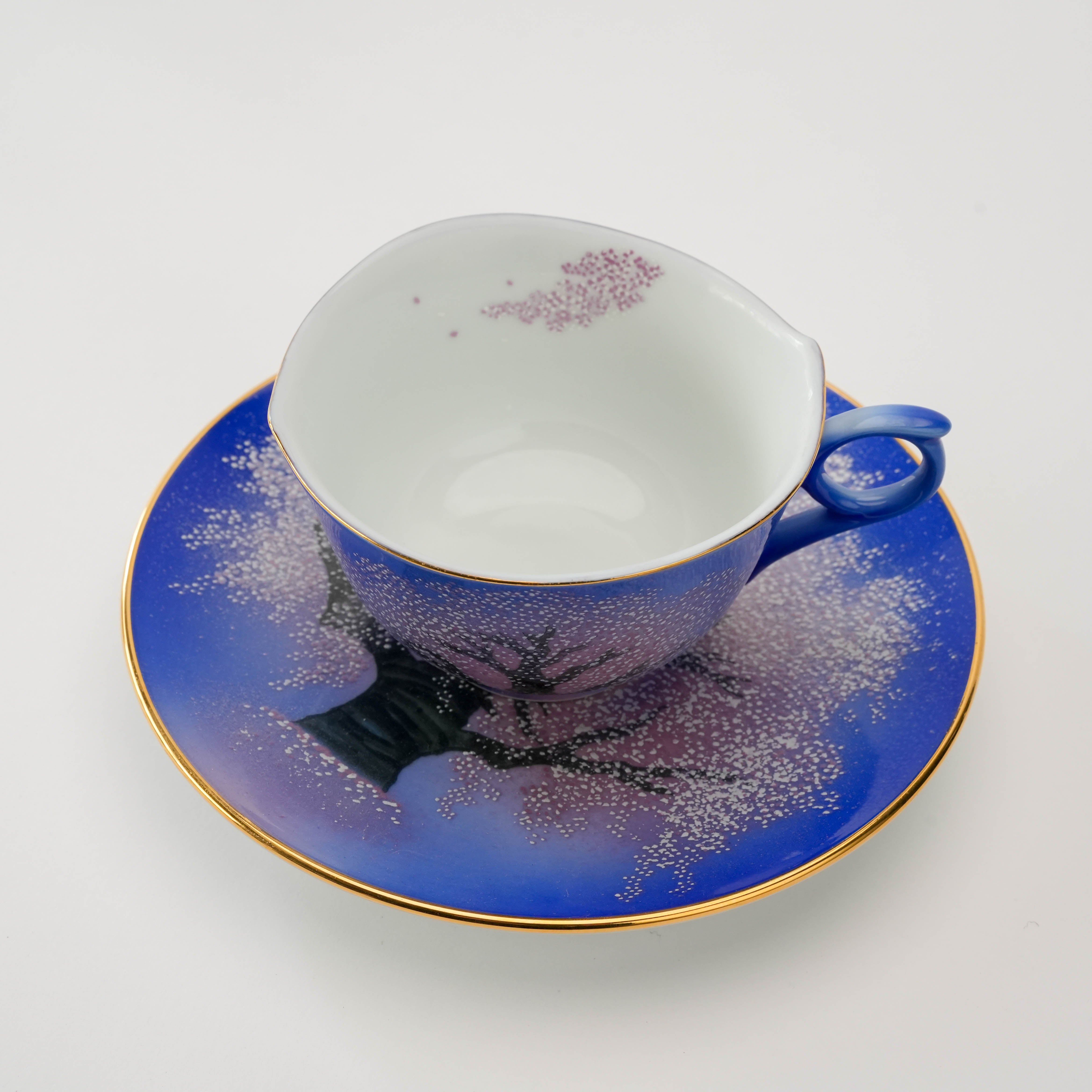 Arita Yozakura Cherry Blossom tea cup placed on matching saucer, showcasing full cherry blossom artwork and refined craftsmanship.