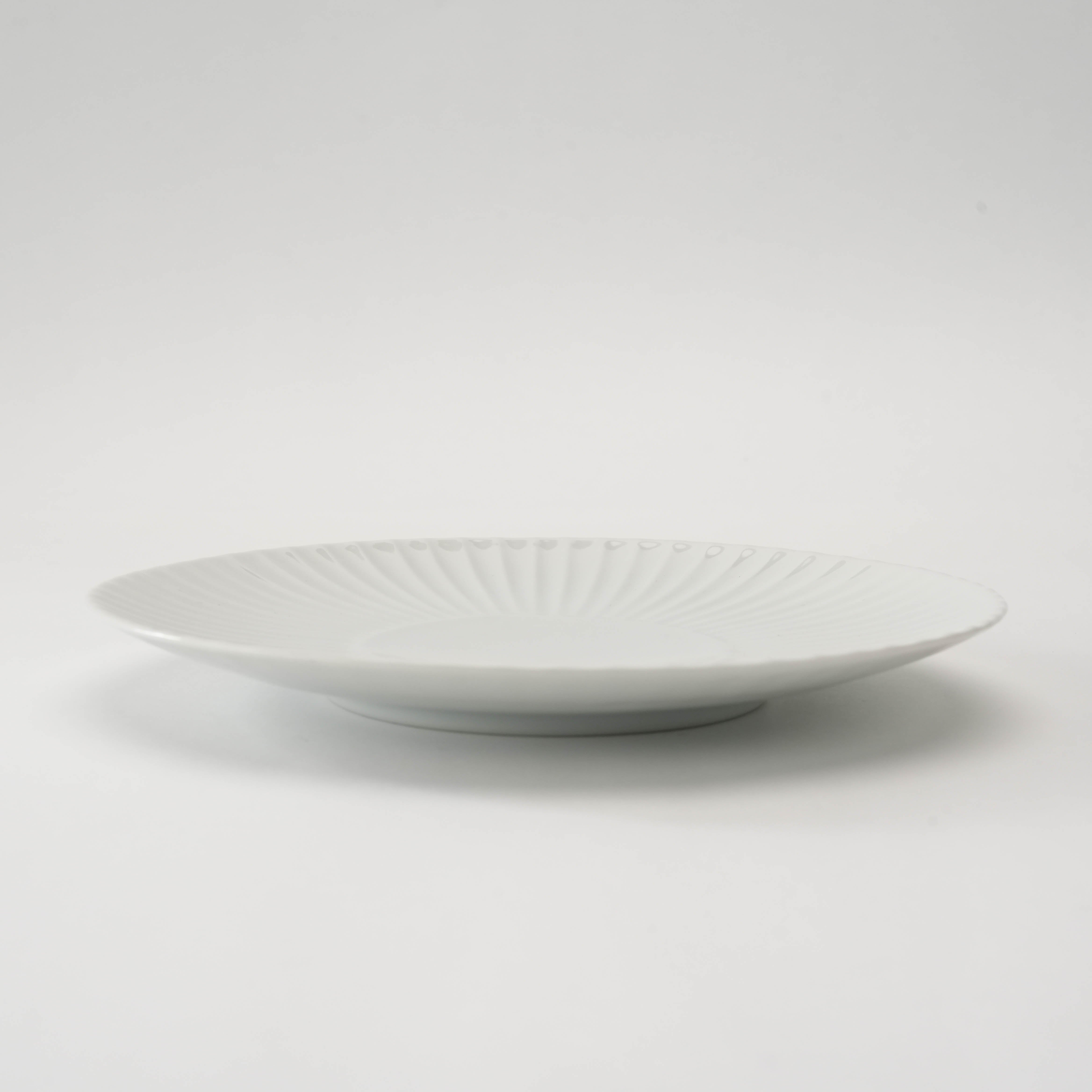Side profile of white Arita Ware Plate - Medium Plate, highlighting its smooth, shallow form and refined craftsmanship for everyday dining.