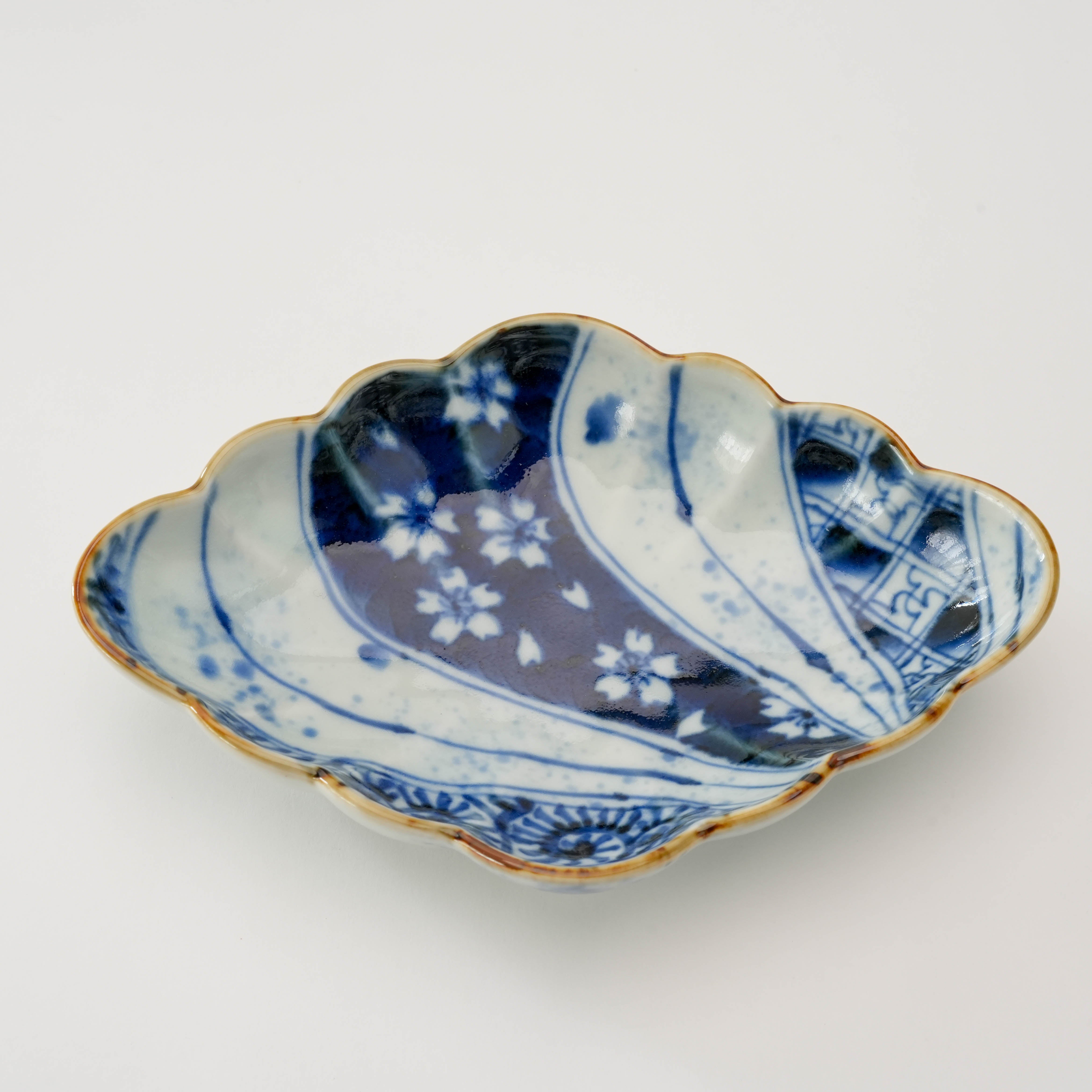 Close-up of Arita Ware Diamond Bowl - Fukusen Kiln highlighting its blue-and-white floral glaze and scalloped rim, 18cm×12cm×4cm.
