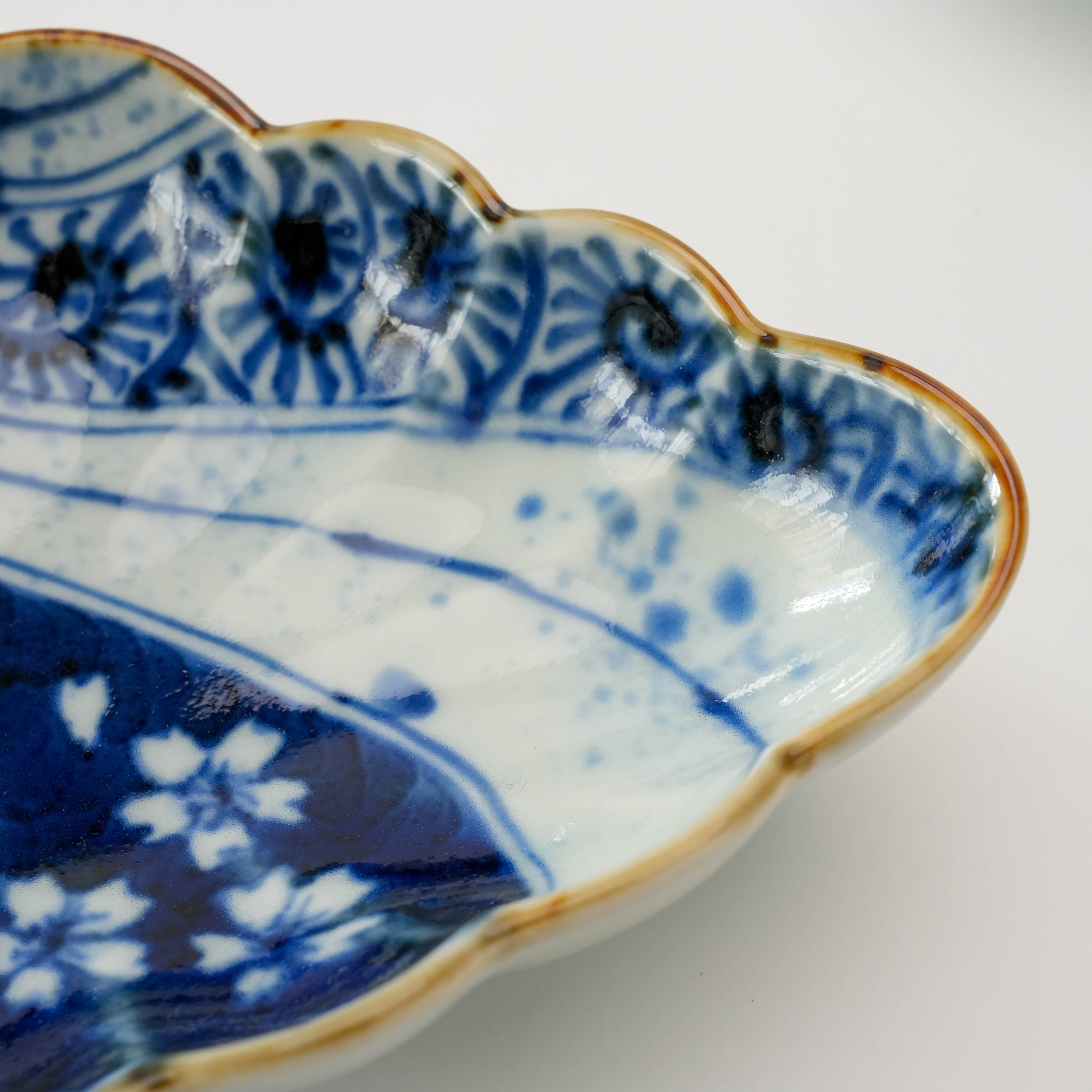 Zoomed-in view of the Arita Ware Diamond Bowl's intricate blue floral border and glossy finish, crafted by Fukusen Kiln.