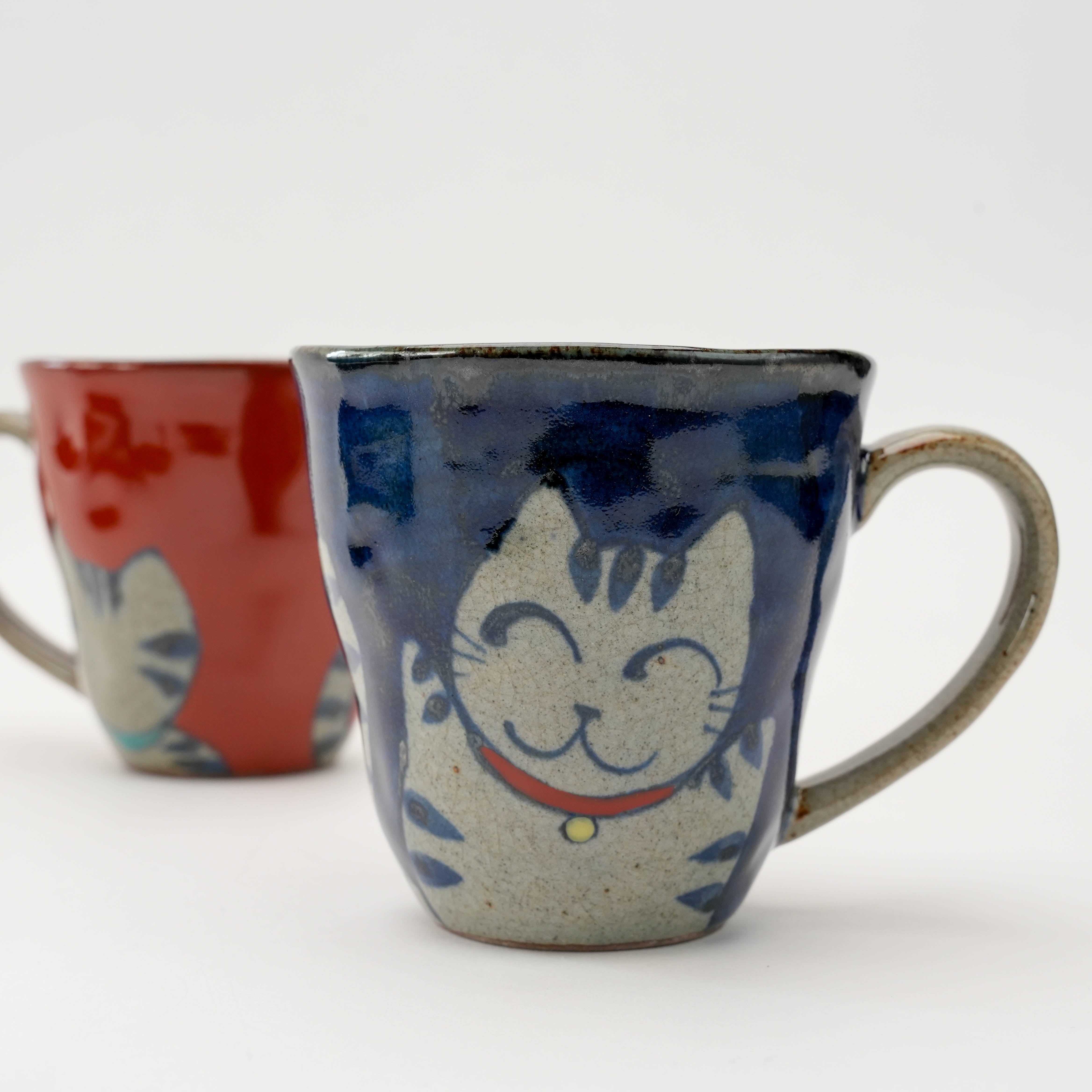 Close-up of blue Arita Ware Lucky Cat Mug featuring joyful feline face, perfect for adding Japanese flair to your drinkware collection.