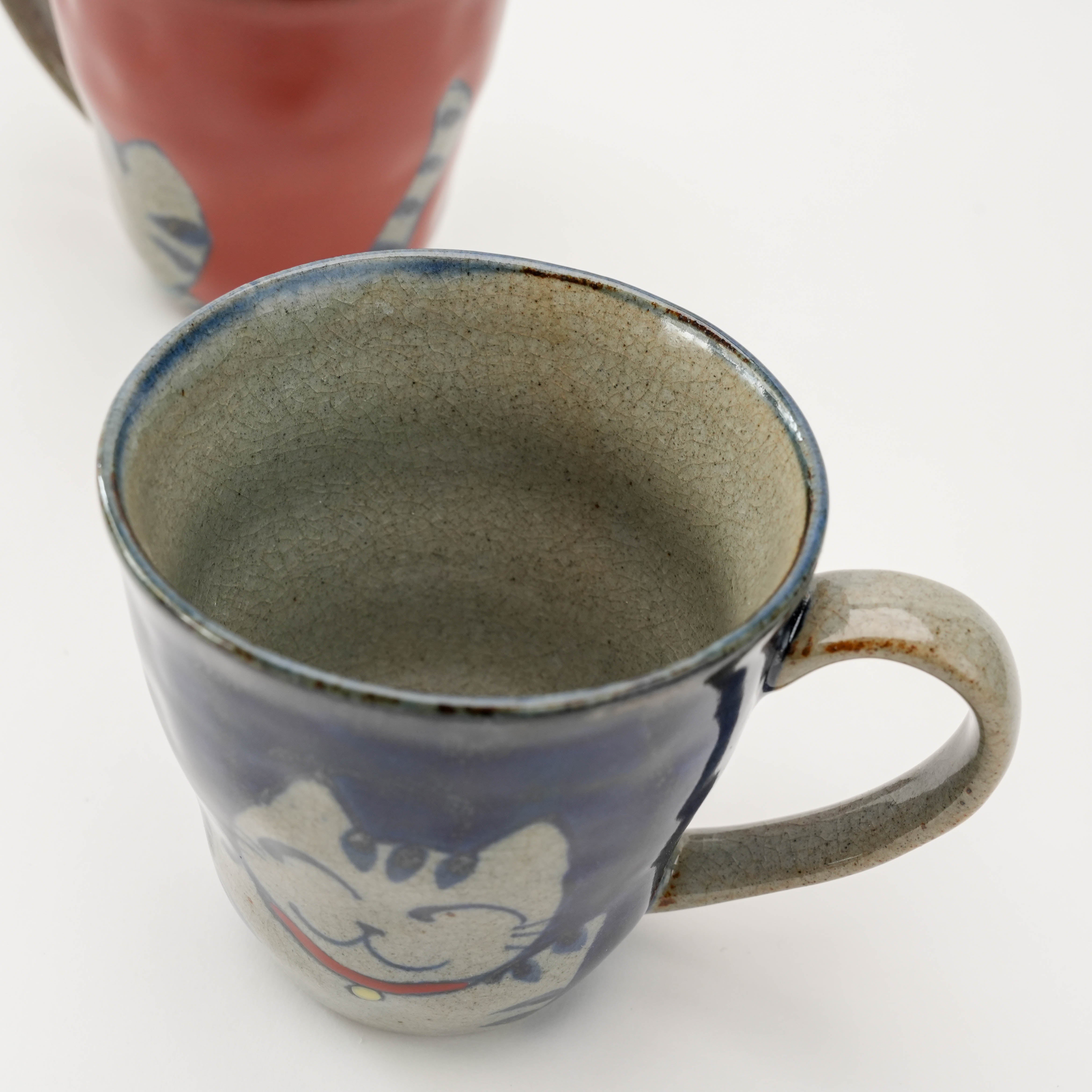 Interior view of blue Arita Ware Lucky Cat Mug with rustic glaze, combining traditional Japanese craftsmanship and playful design.