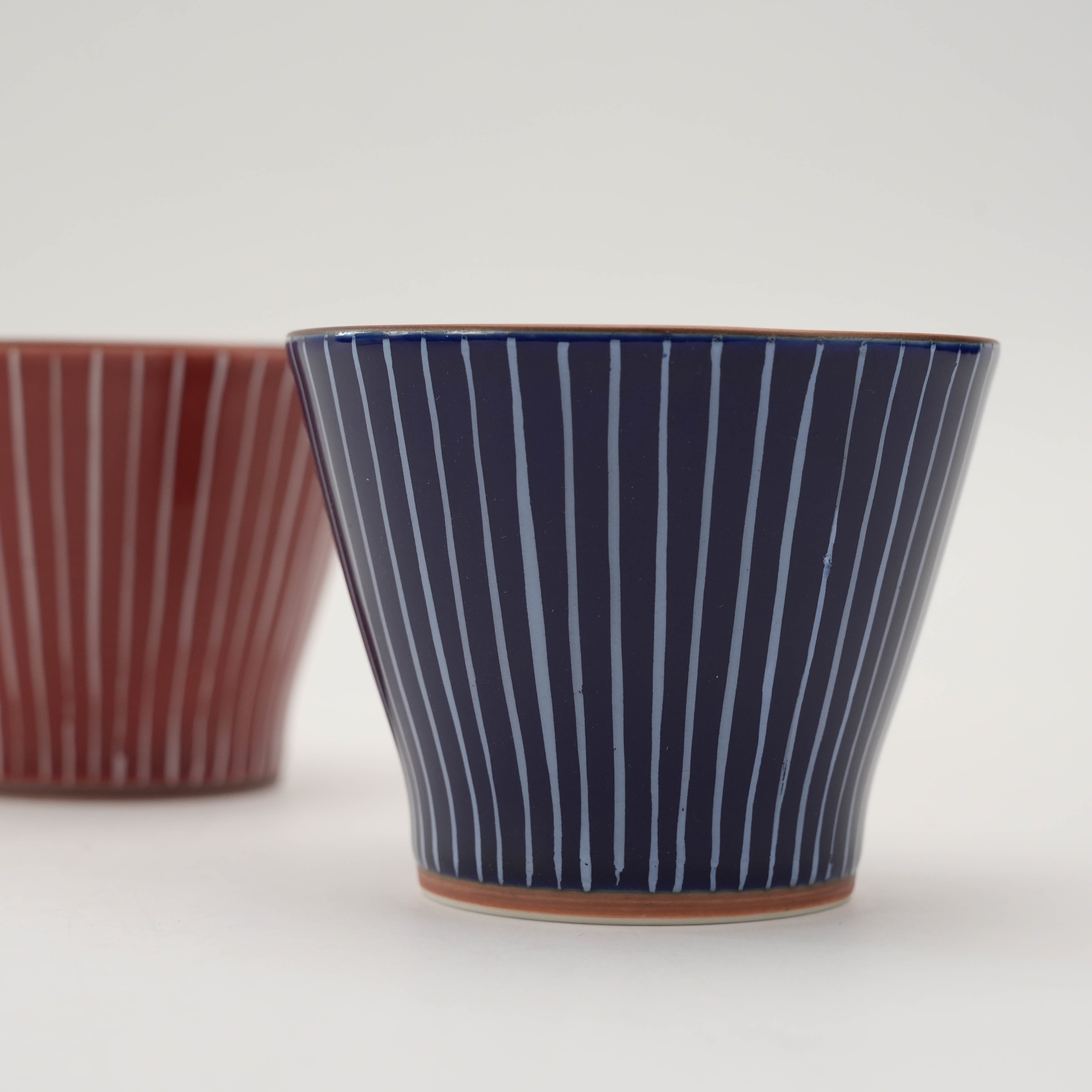 Close-up of blue Shiraito Teacup with red version in background. Hand-painted Japanese teacups with modern rustic charm.