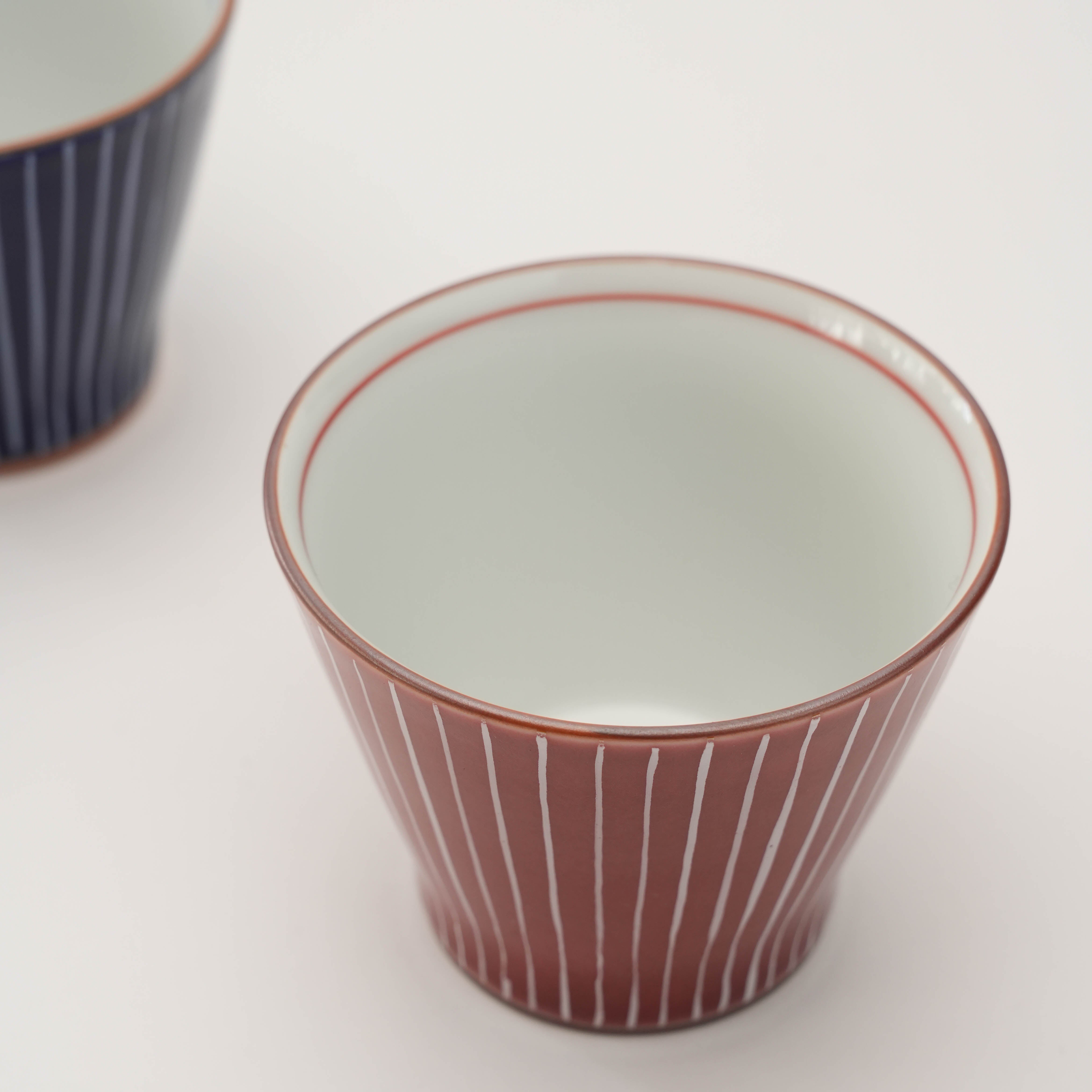 Interior view of red Shiraito Yunomi Teacup with clean white glaze and red rim. Ideal for tea or small servings.