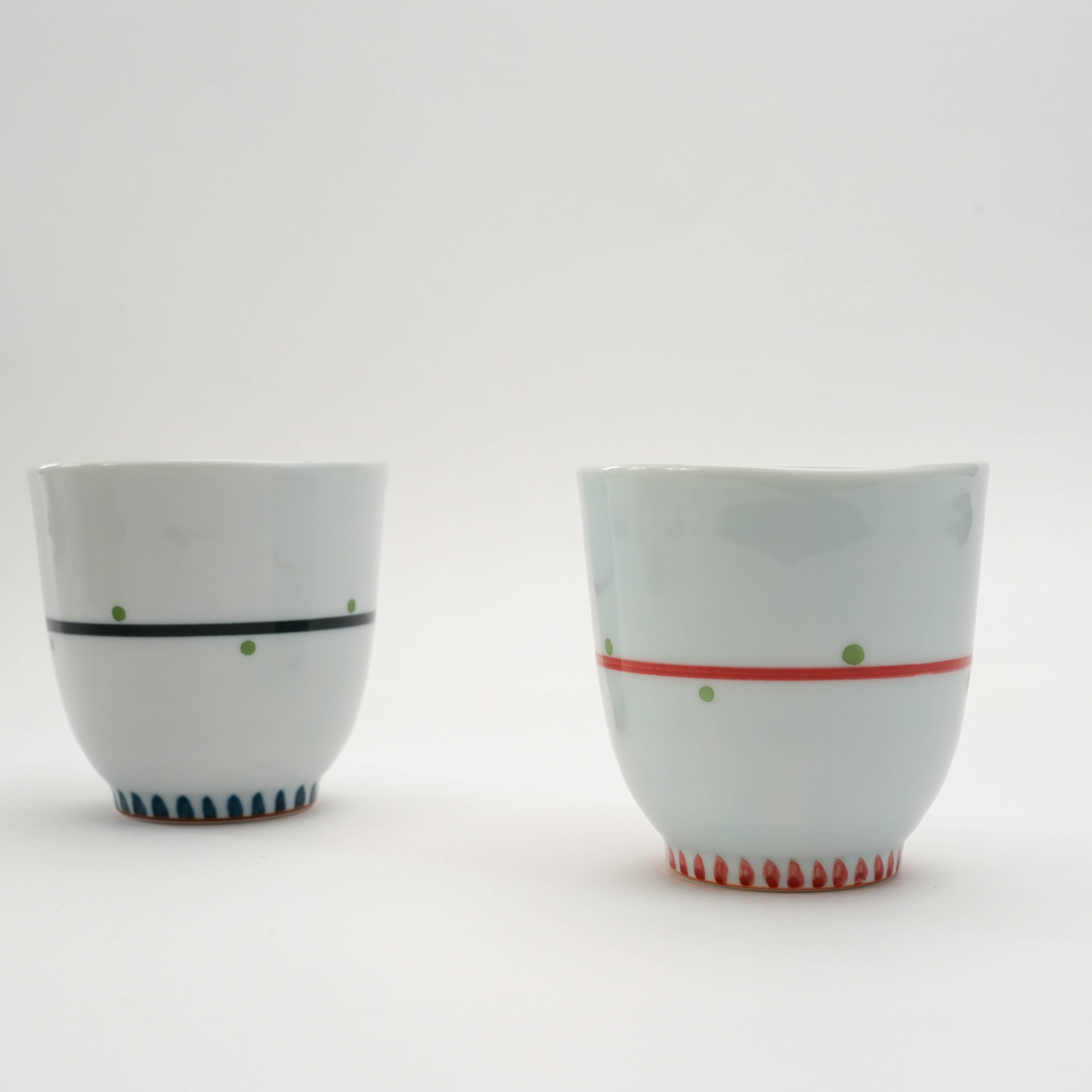 Side view of Arita Ware Owl Teacups in red and blue with dotted lines and textured base. Elegant Japanese porcelain mugs.