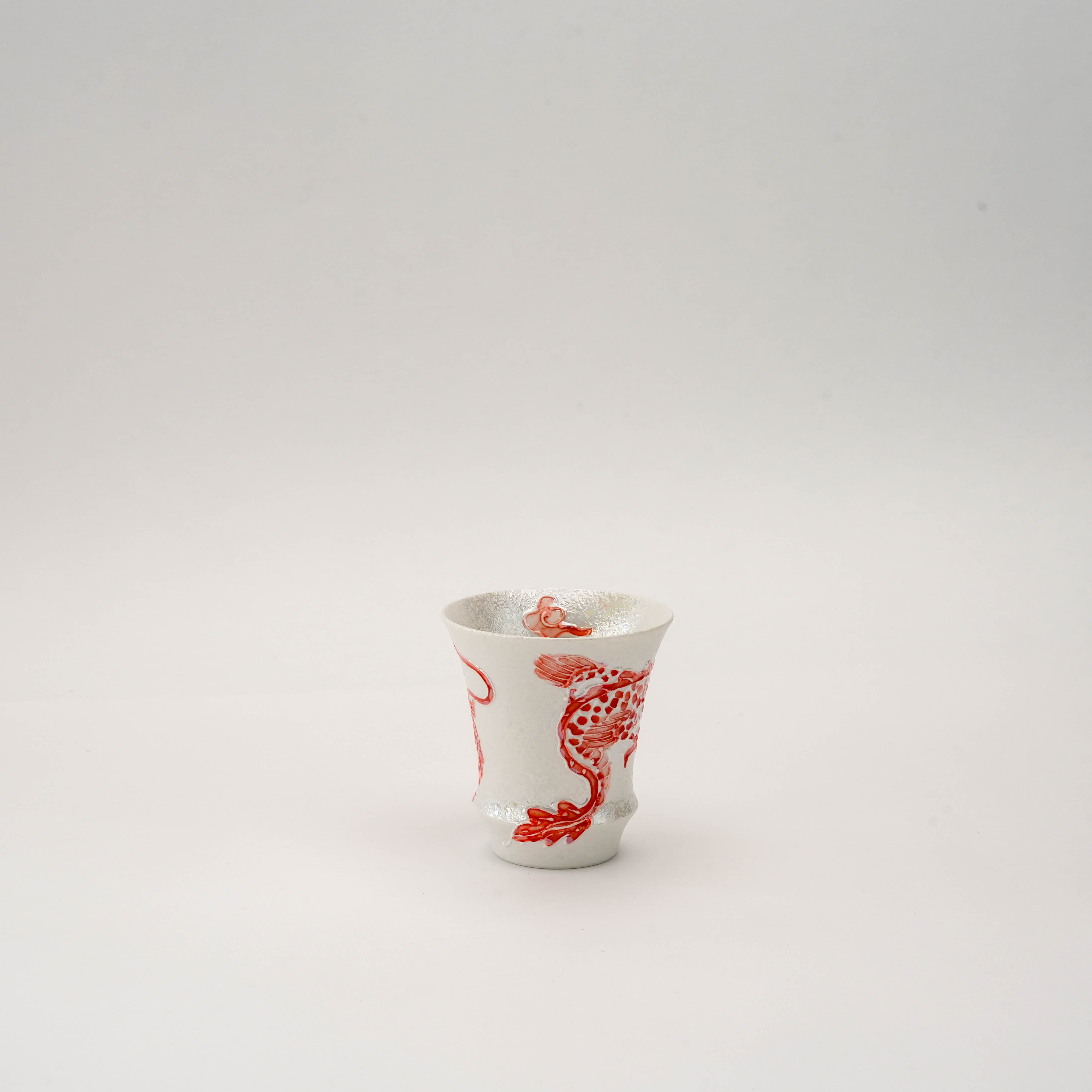 Angled view of the Arita Ware Fire Dragon Sake Glass highlighting the intricate hand-painted dragon scales and textured silver finish.