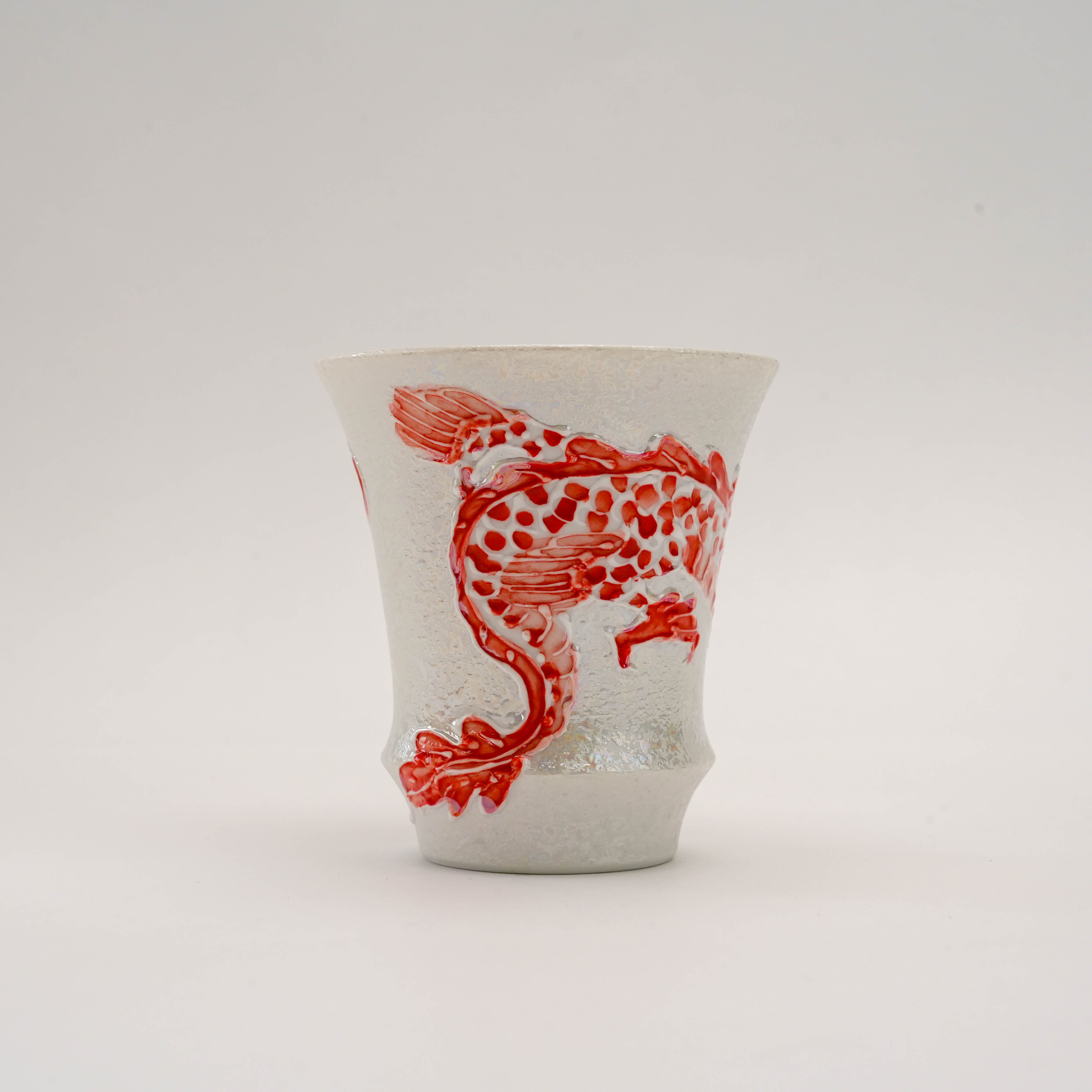 Back view of the Fire Dragon Sake Glass emphasizing the dragon's legs and tail in raised red enamel on a silver-glazed porcelain surface.