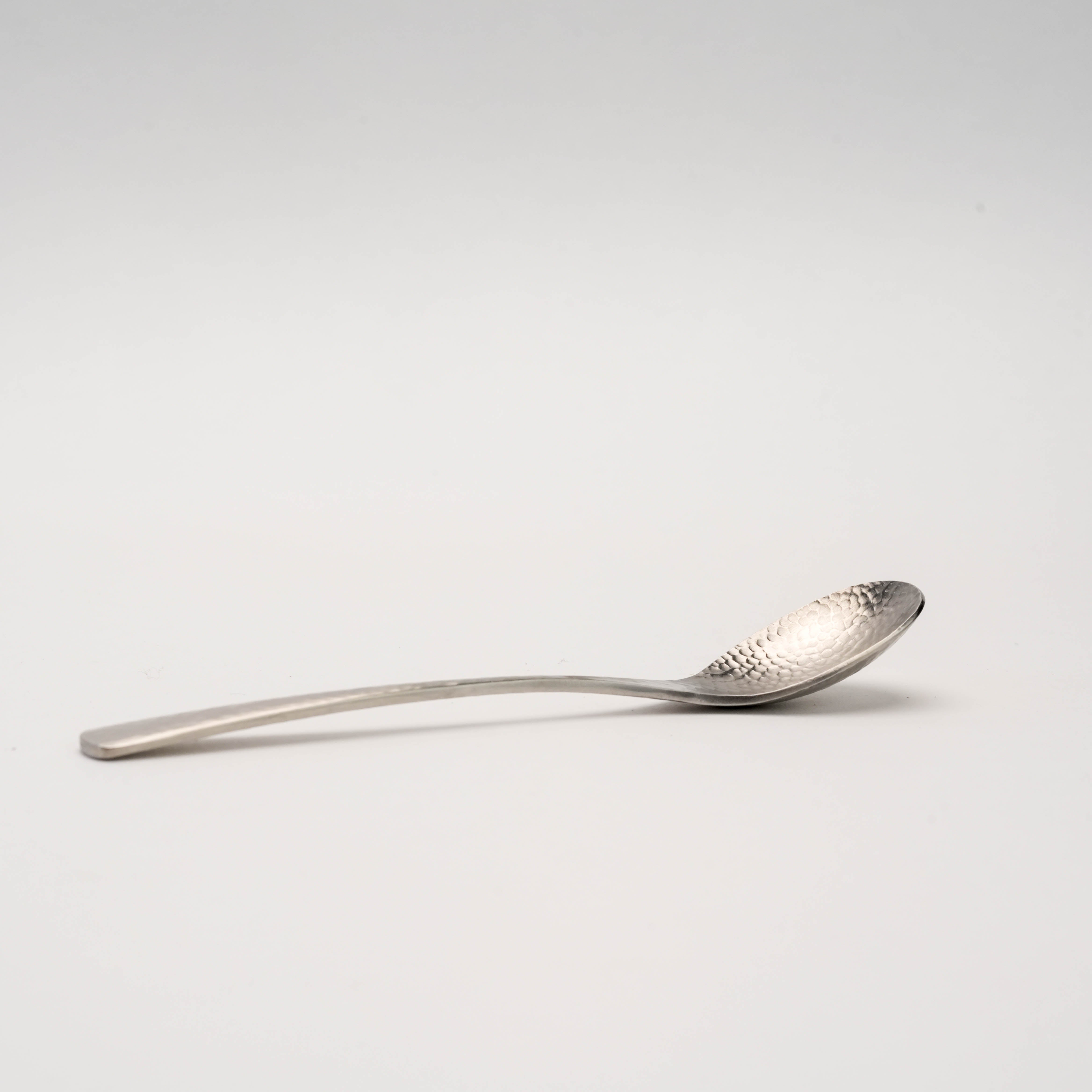 Side profile of the Tsubamesanjo Hammered Spoon - Nagomi Wafu Tea, highlighting its curved shape and artisanal craftsmanship.