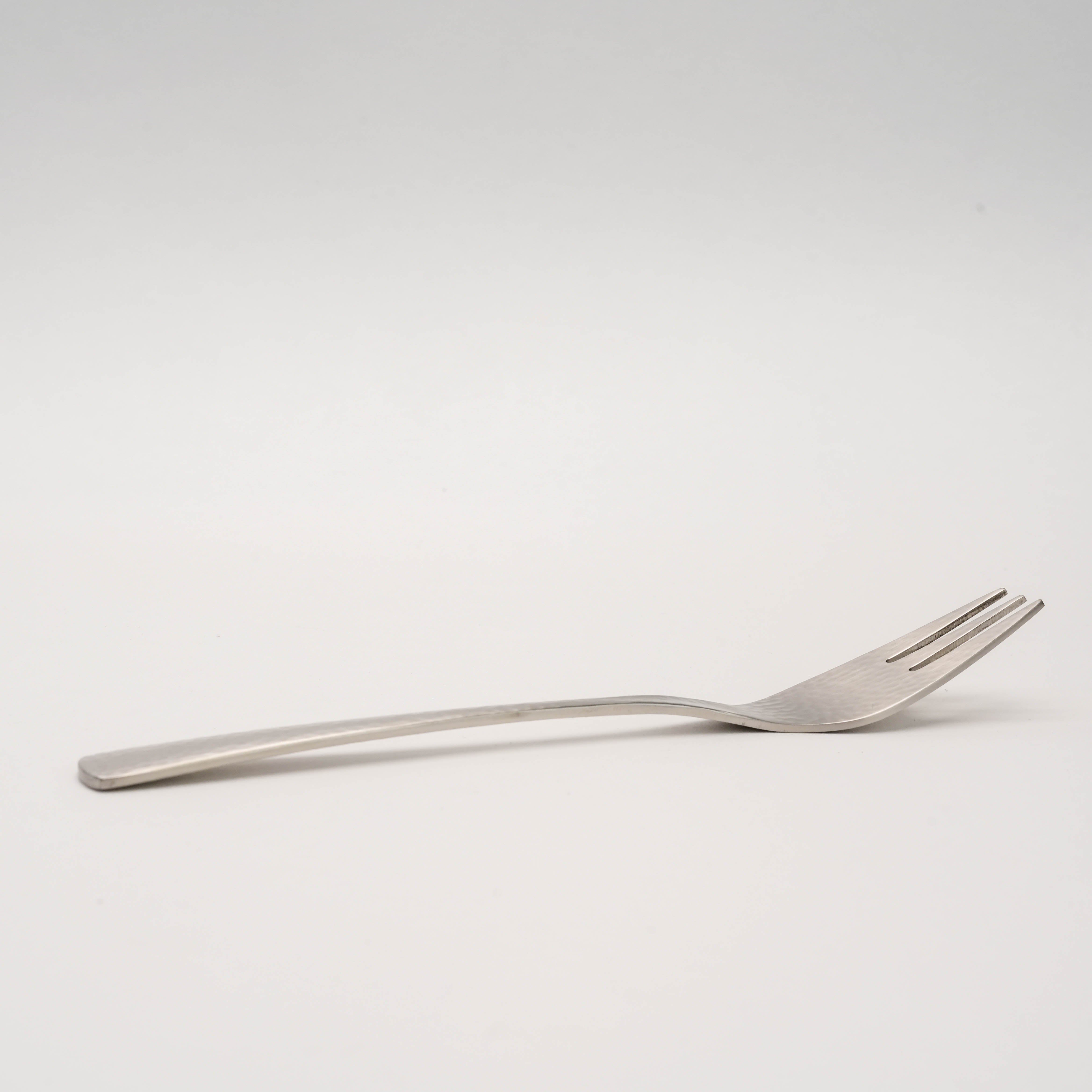 Side view of Tsubamesanjo Nagomi Fork - Hammered Finish | Japanese Craft highlighting its ergonomic curve and artisanal hammered texture.