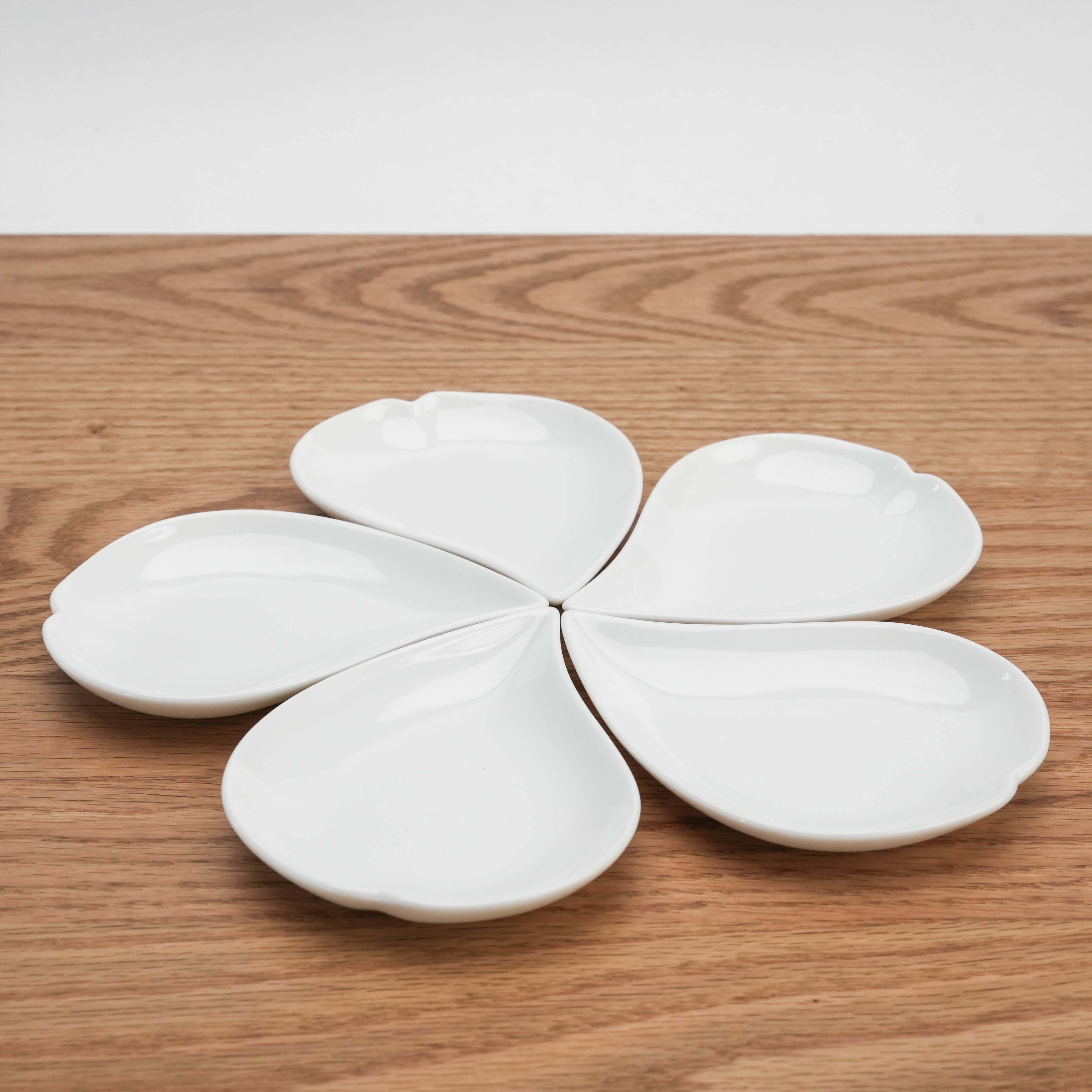 Five Mino Ware Sakura Petal Plates arranged in a flower shape on wooden table, ideal for serving appetizers or desserts.