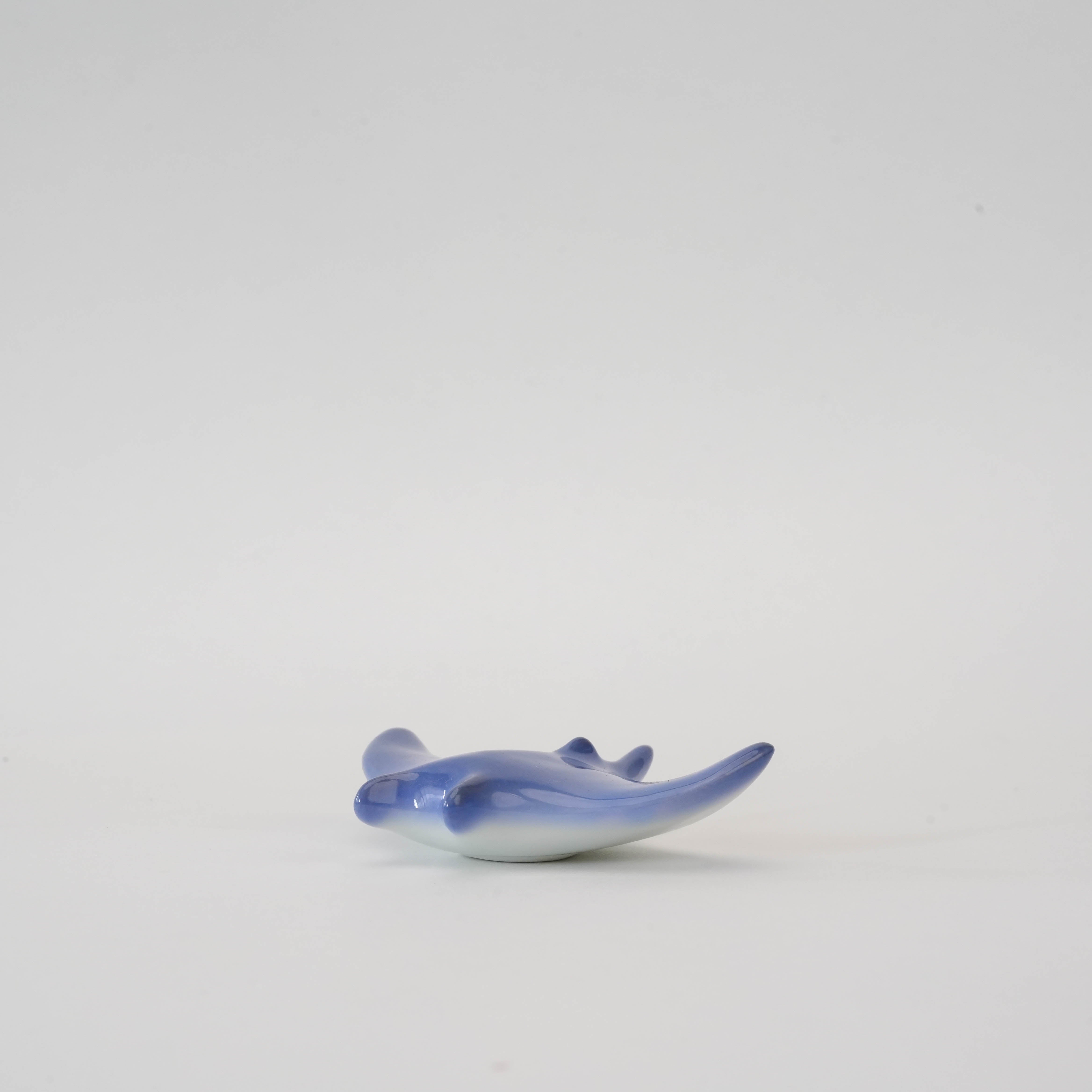 Side angle of ocean blue Arita porcelain manta ray chopstick holder, blending artistic form with practical tableware use.