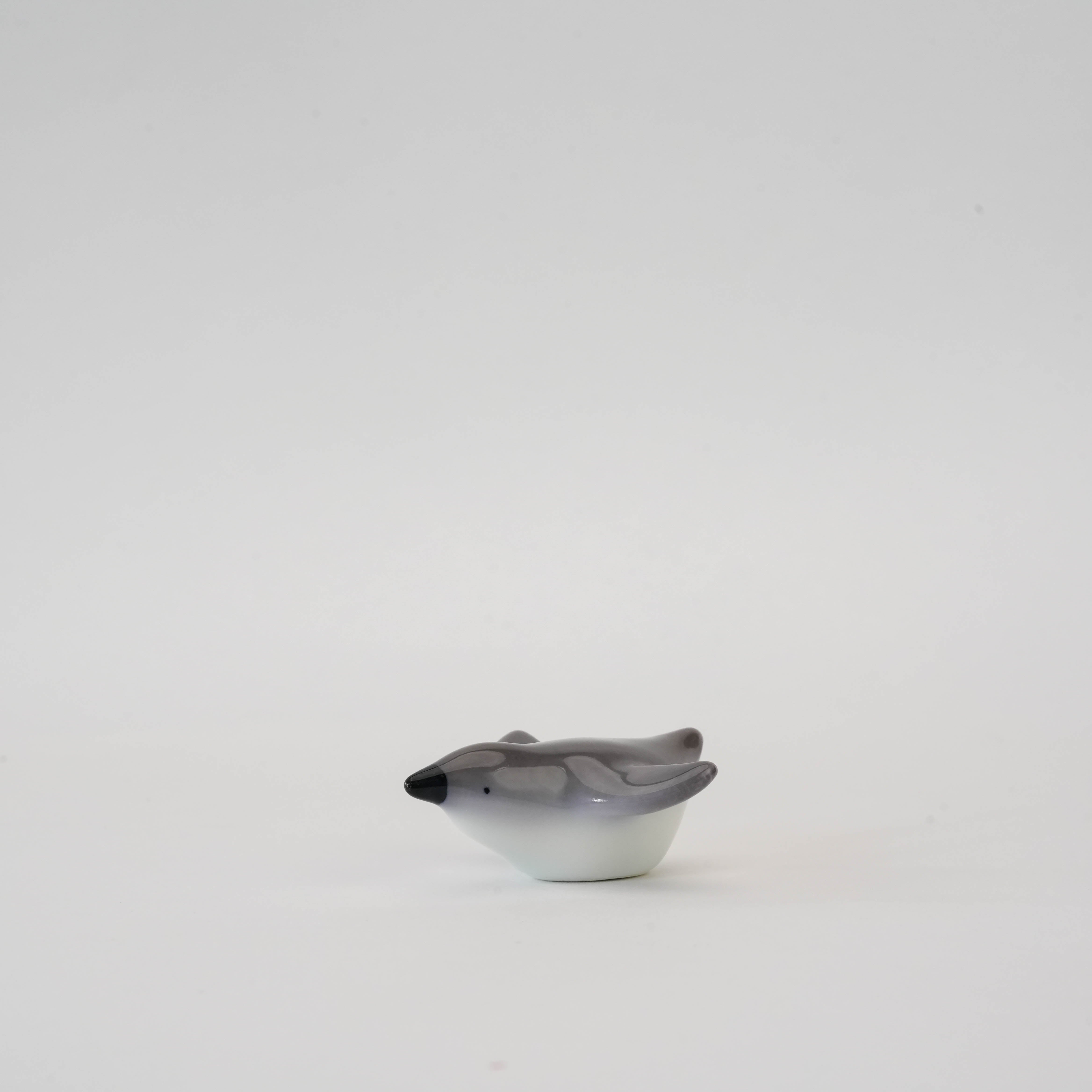 Side profile of Penguin Chopstick Rest - Arita Ware, featuring a sleek gray and white finish perfect for modern tableware collections.