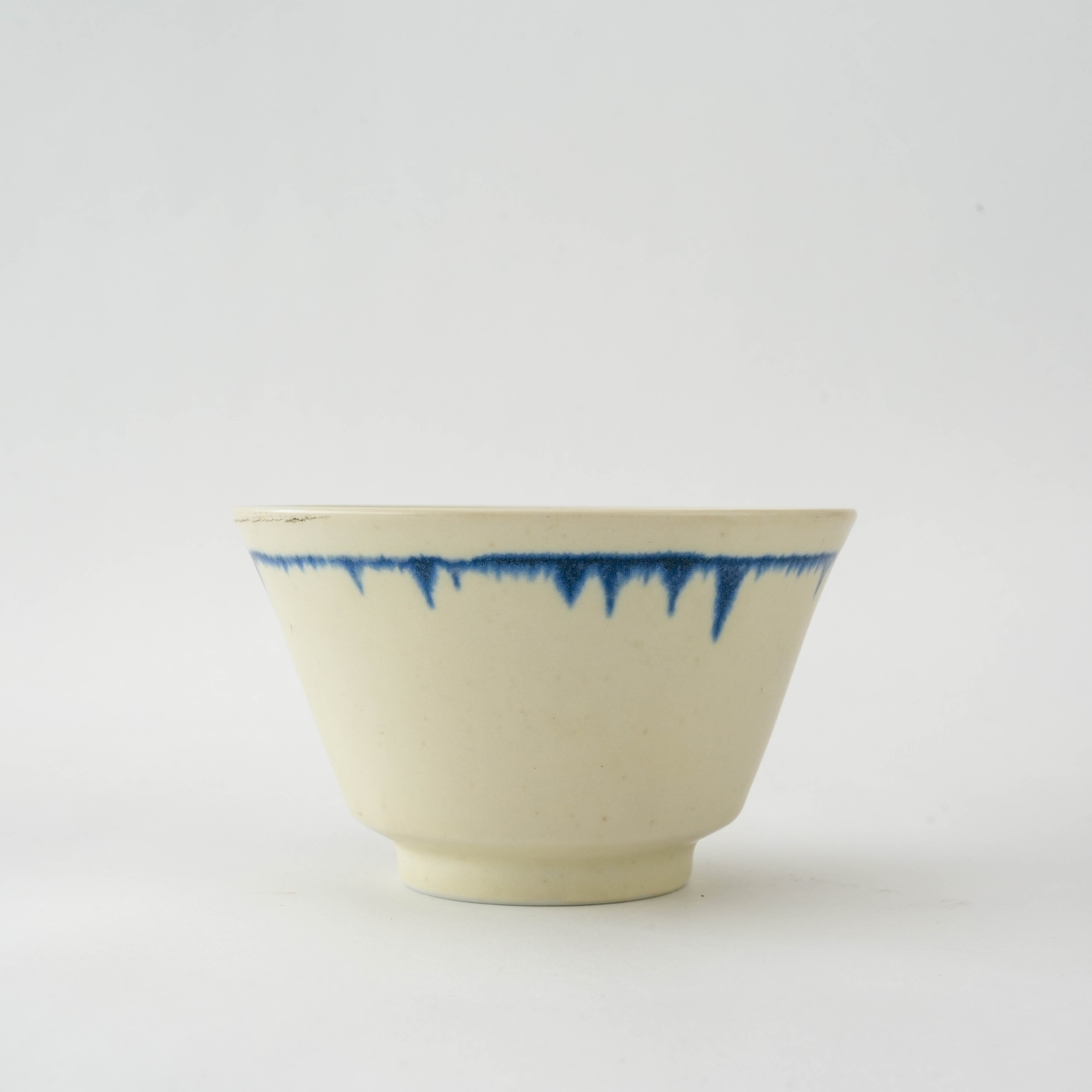 Side view of Cream Nagashi Rice Bowl - Mino Ware showcasing hand-applied blue glaze on cream ceramic, a refined piece for modern dinnerware sets.