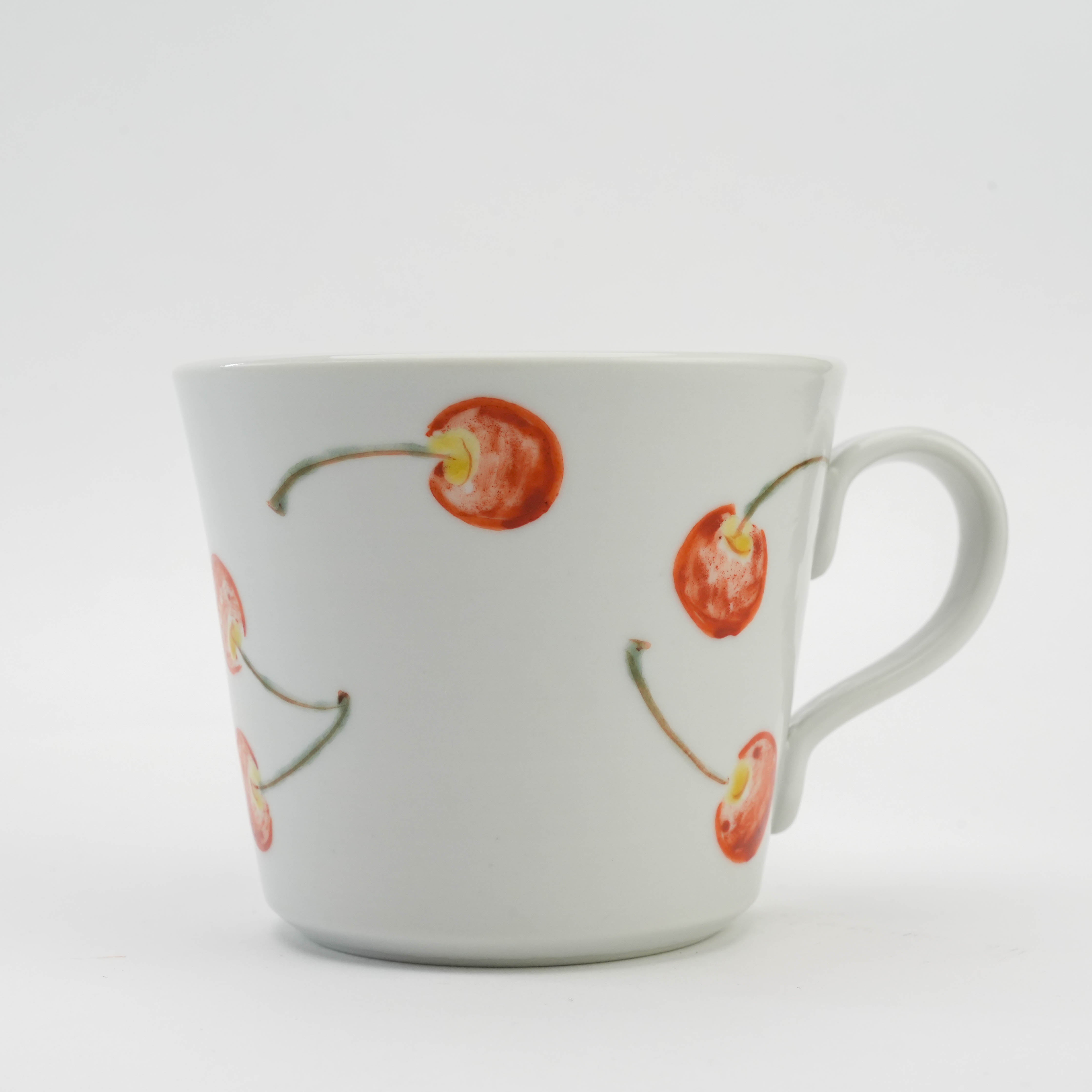 Close-up of Kutani Ware Cherry Pattern Mug showcasing vivid cherry artwork on smooth white porcelain, a standout piece in drinkware collections.