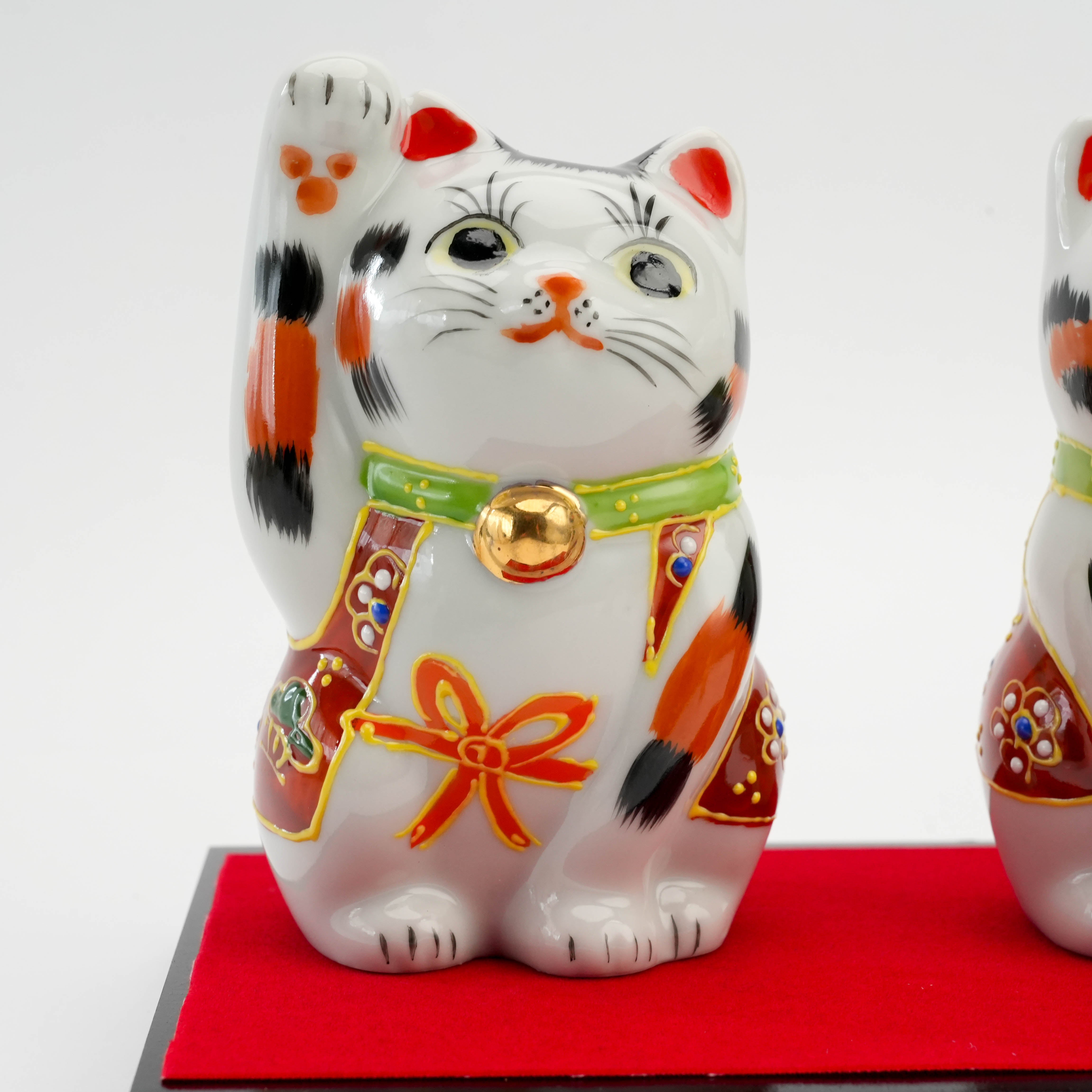 Close-up of one Kutani Calico Lucky Cat - Custom Cat Ornament with raised paw and gold bell, symbolizing prosperity and good fortune.