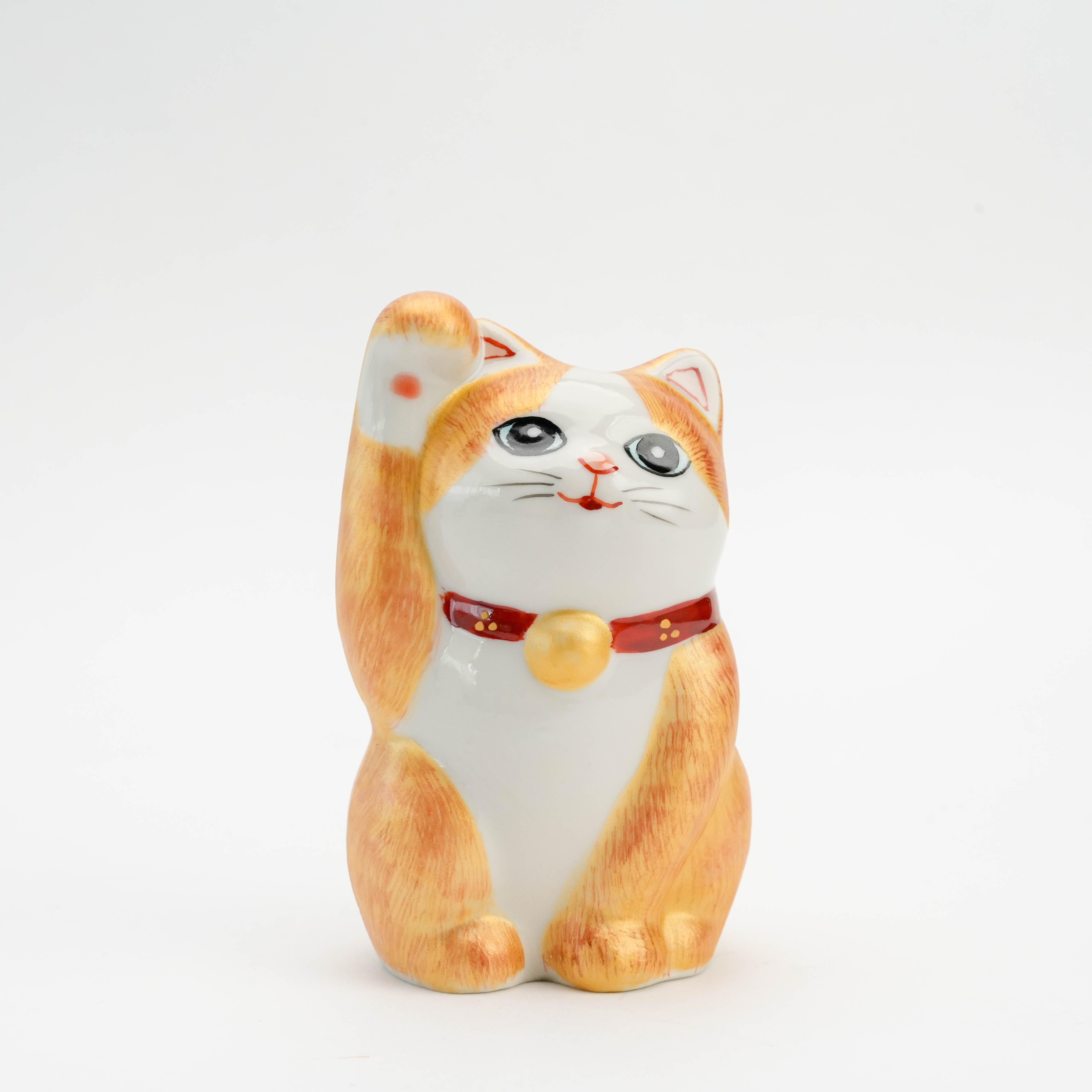 Kutani Ware Cat Ornament in sitting pose with raised paw, gold accents, and intricate hand-painted fur. Perfect decorative piece for shelves or mantels.