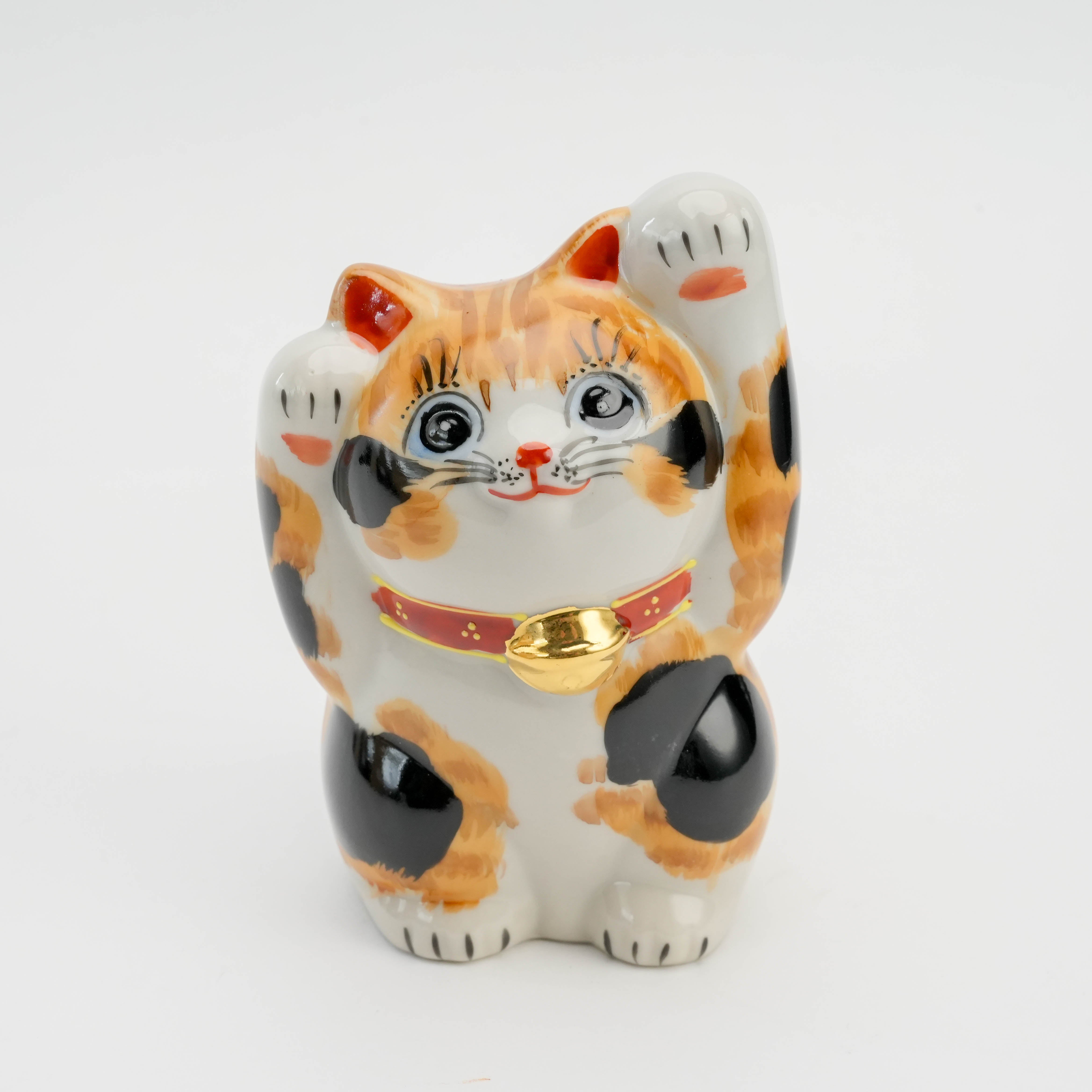 Front close-up of Kutani Ware Calico Maneki-neko with gold bell and expressive eyes, symbolizing wealth and good fortune in Japanese tradition.