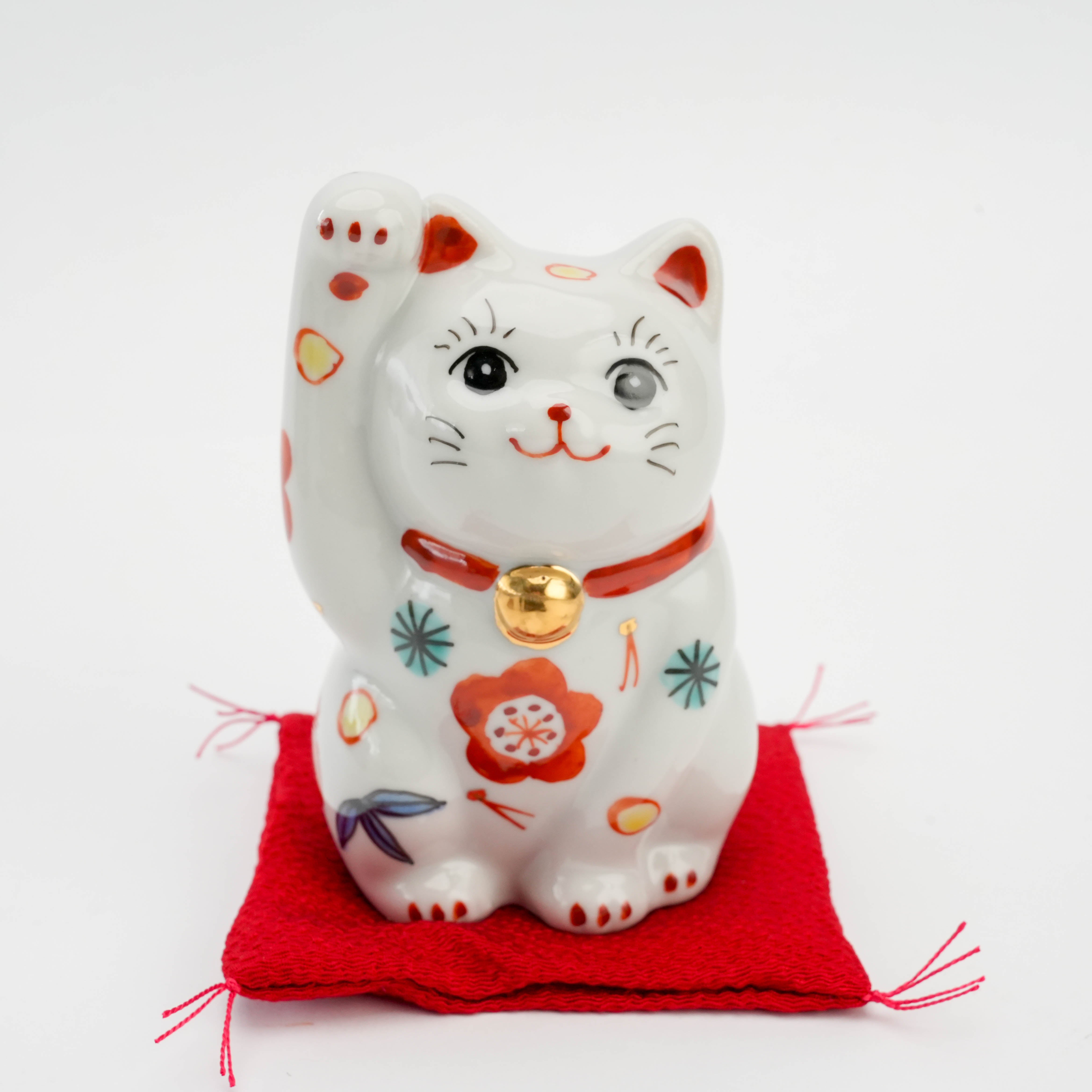 Front close-up of Kutani Ware Pine Cat Ornament with raised paw and gold bell, detailed with traditional Japanese lucky symbols.