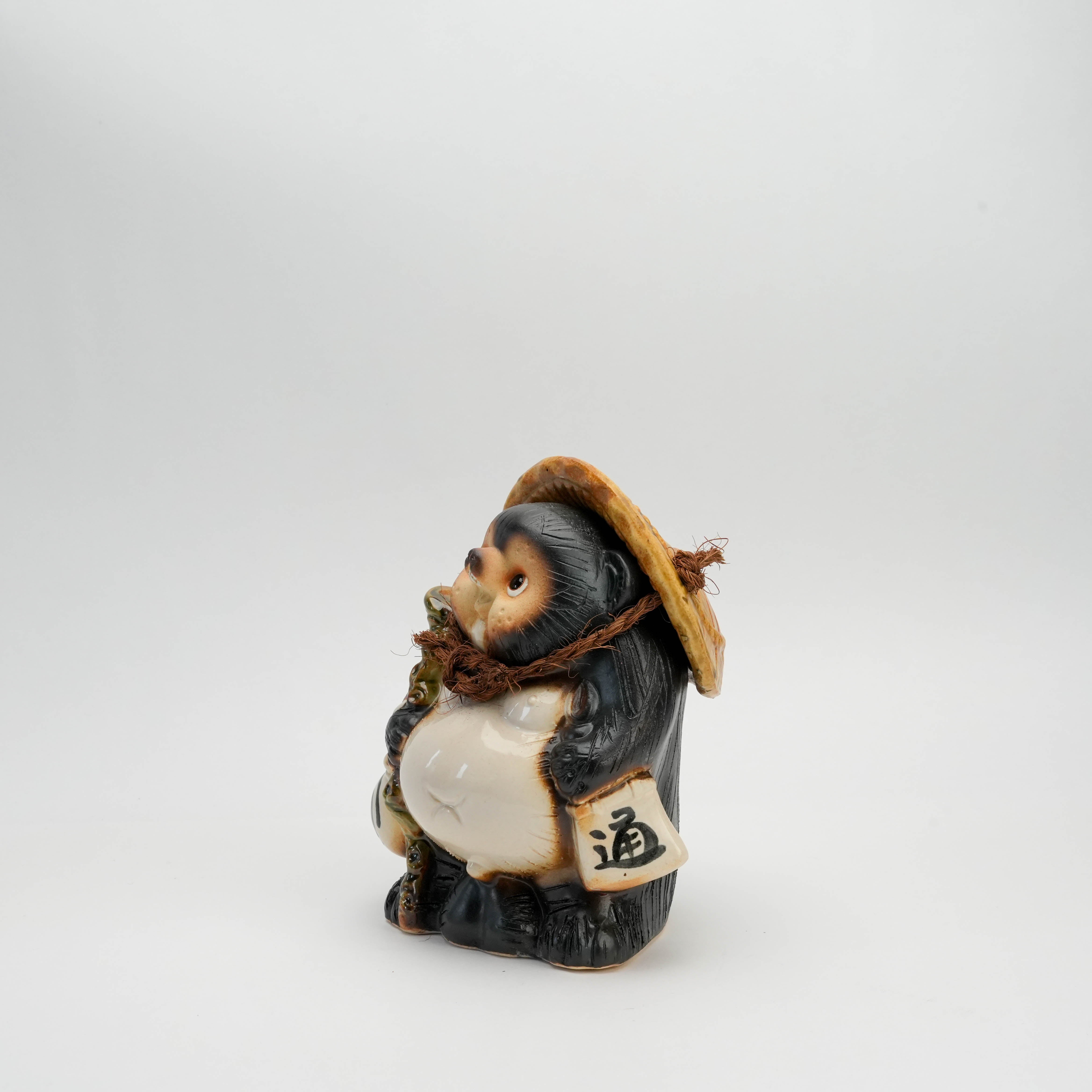 Side profile of Tanuki Raccoon Ornament - Shigaraki Ware | Lucky Charm highlighting the tanuki's scroll and textured fur design.