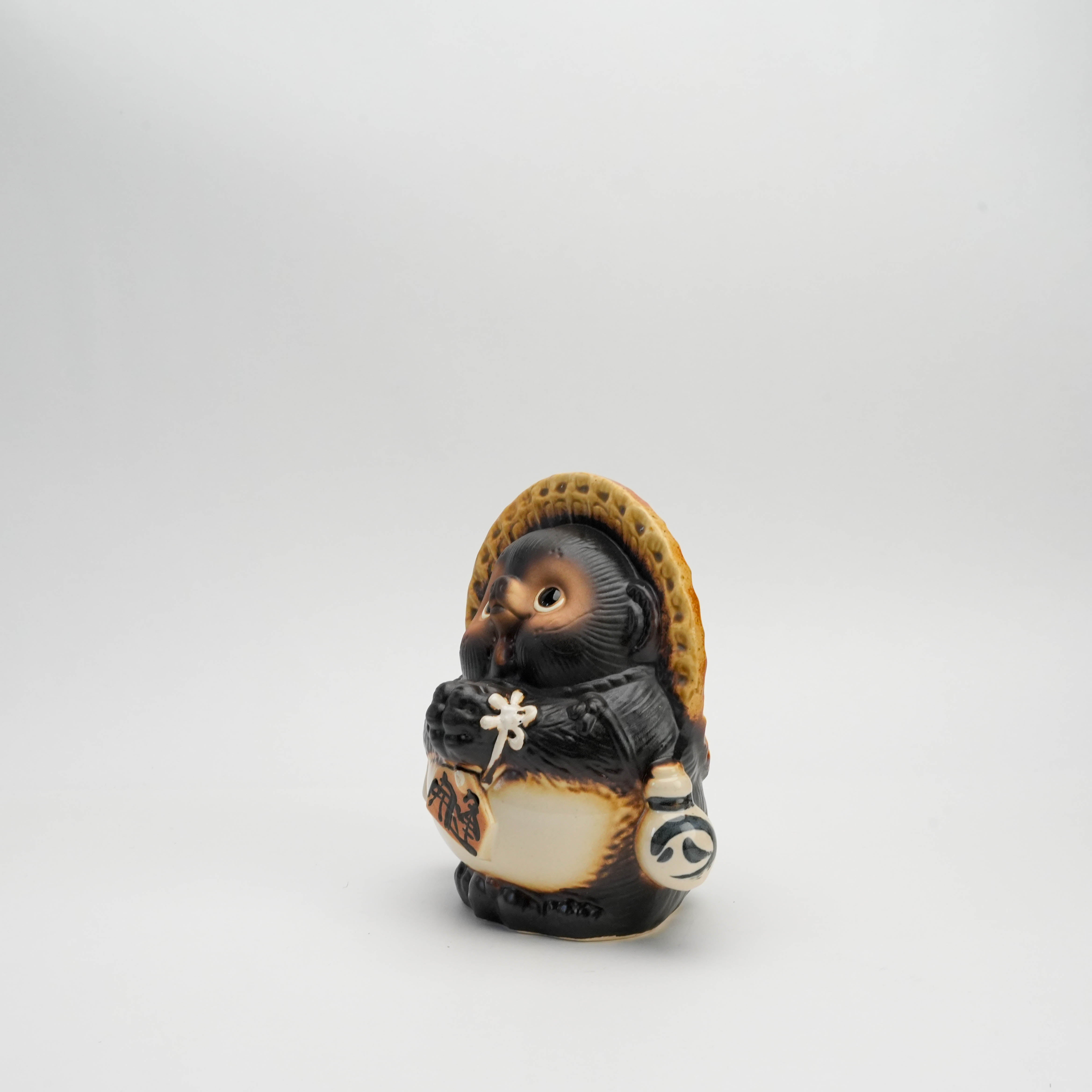Angled view of handcrafted Shigaraki Tanuki ornament featuring detailed ceramic design and traditional Japanese symbolism.