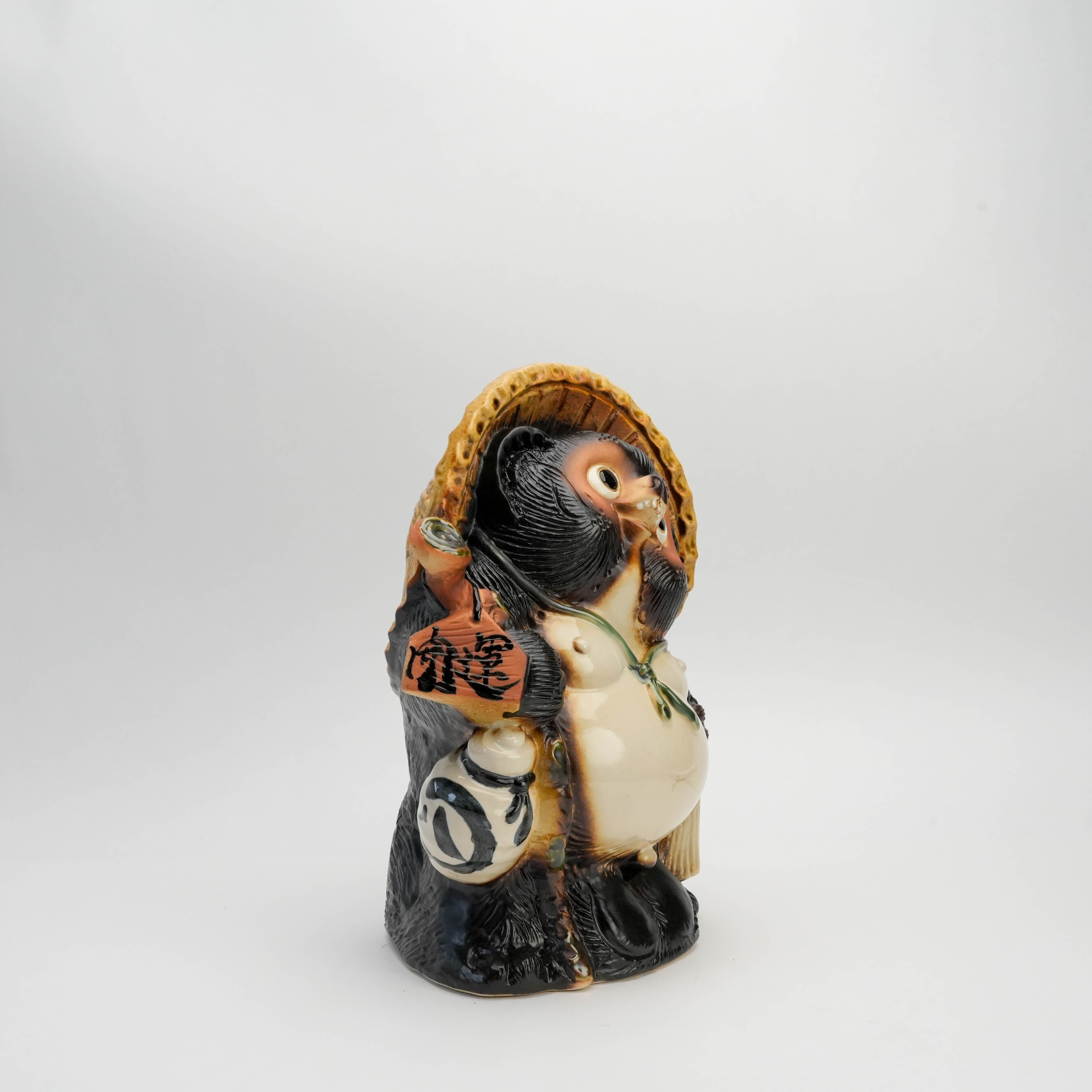 Side view of Shigaraki Kaiun Raccoon Dog Ornament showing detailed craftsmanship and traditional lucky charms, ideal for garden or interior display.