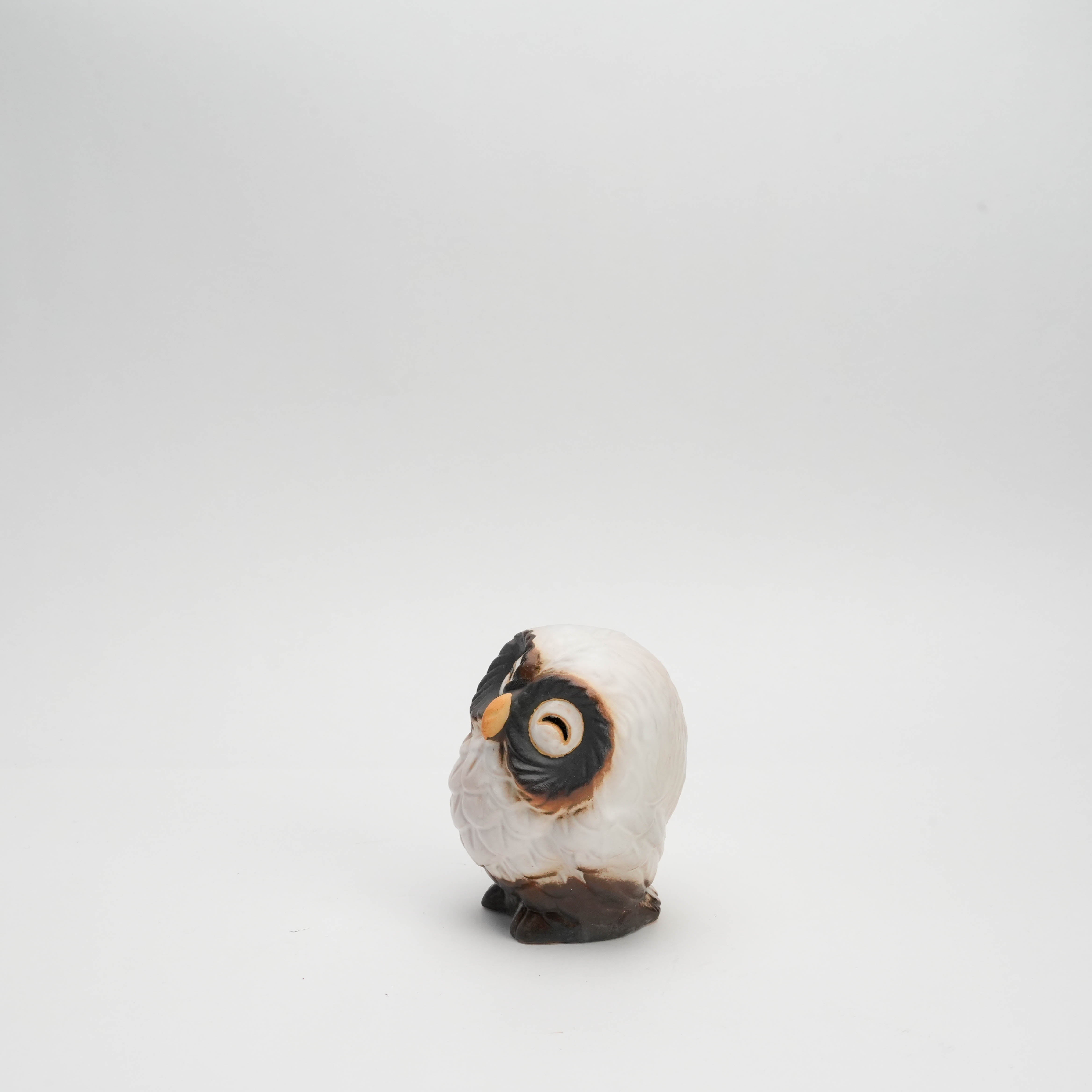 Angled side view of small Shigaraki Ware white owl ornament with a joyful face and textured ceramic feathers, perfect for holiday decor.