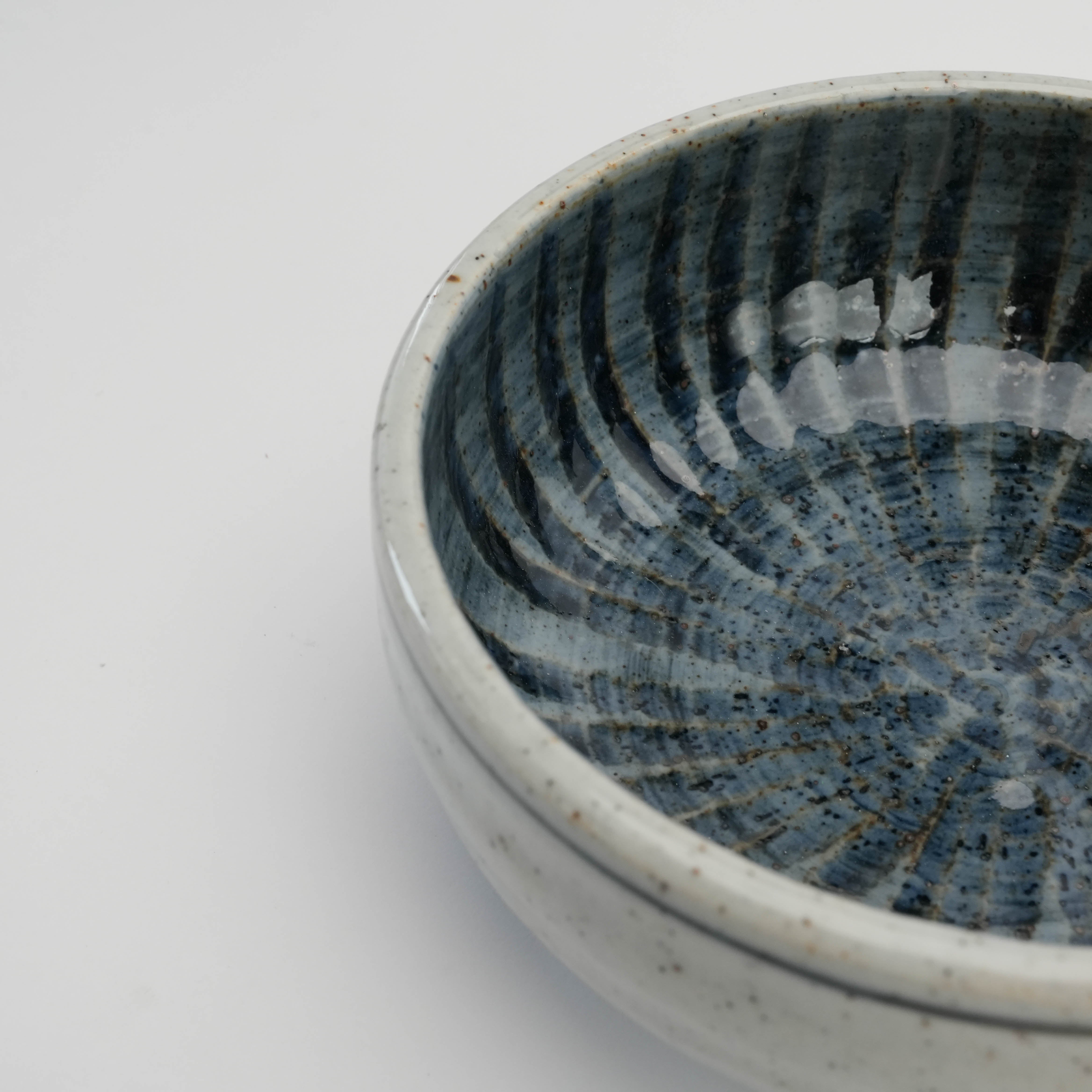 Close-up of Mino Ware Ishiyaki Bowl interior highlighting glossy indigo spiral glaze, a traditional Japanese dinnerware piece.