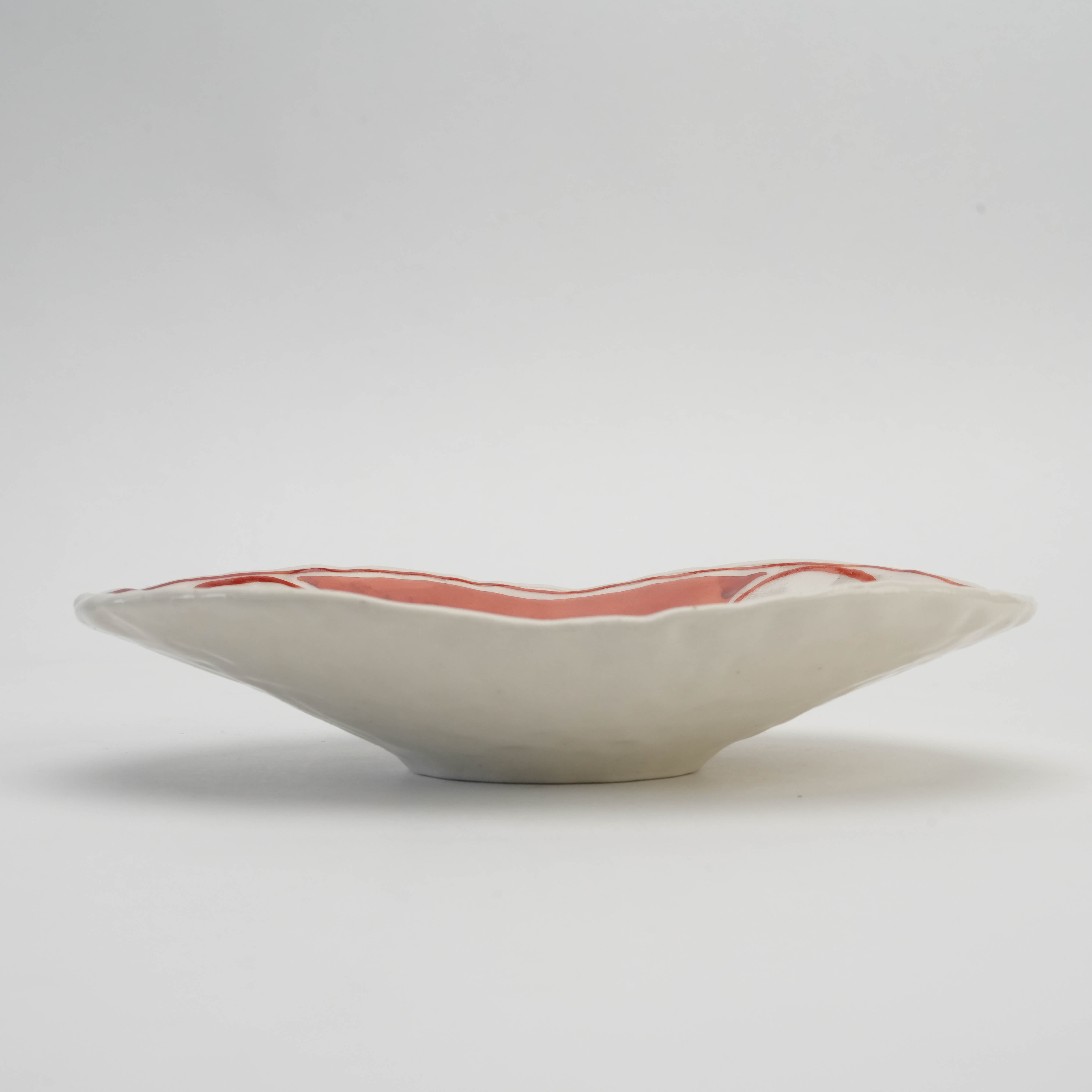Side view of Mino Ware Akae Oval Serving Dish with a shallow, curved profile and hand-painted Japanese motifs.