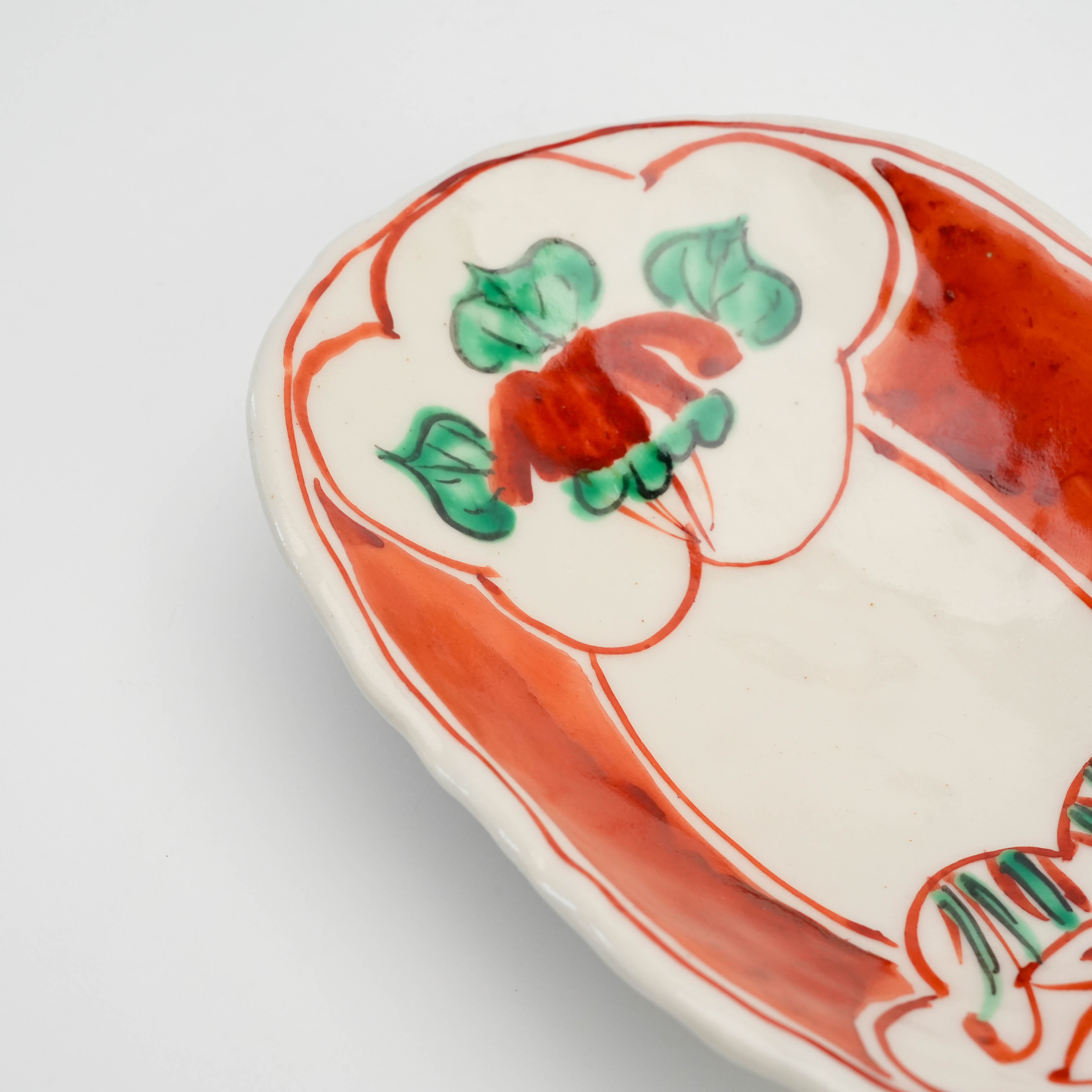 Close-up of Mino Ware Oval Dish showcasing intricate hand-painted red and green floral design on a white ceramic base.